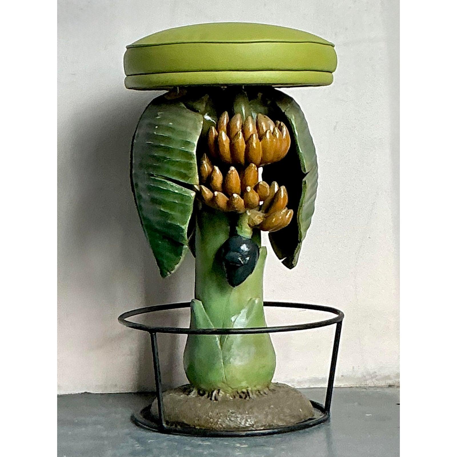 Inject a playful and exotic flair into your decor with this extraordinary vintage stool, masterfully carved to resemble a banana tree. This unique piece captures the whimsical spirit of Boho Chic and Tropical aesthetics, featuring a base intricately