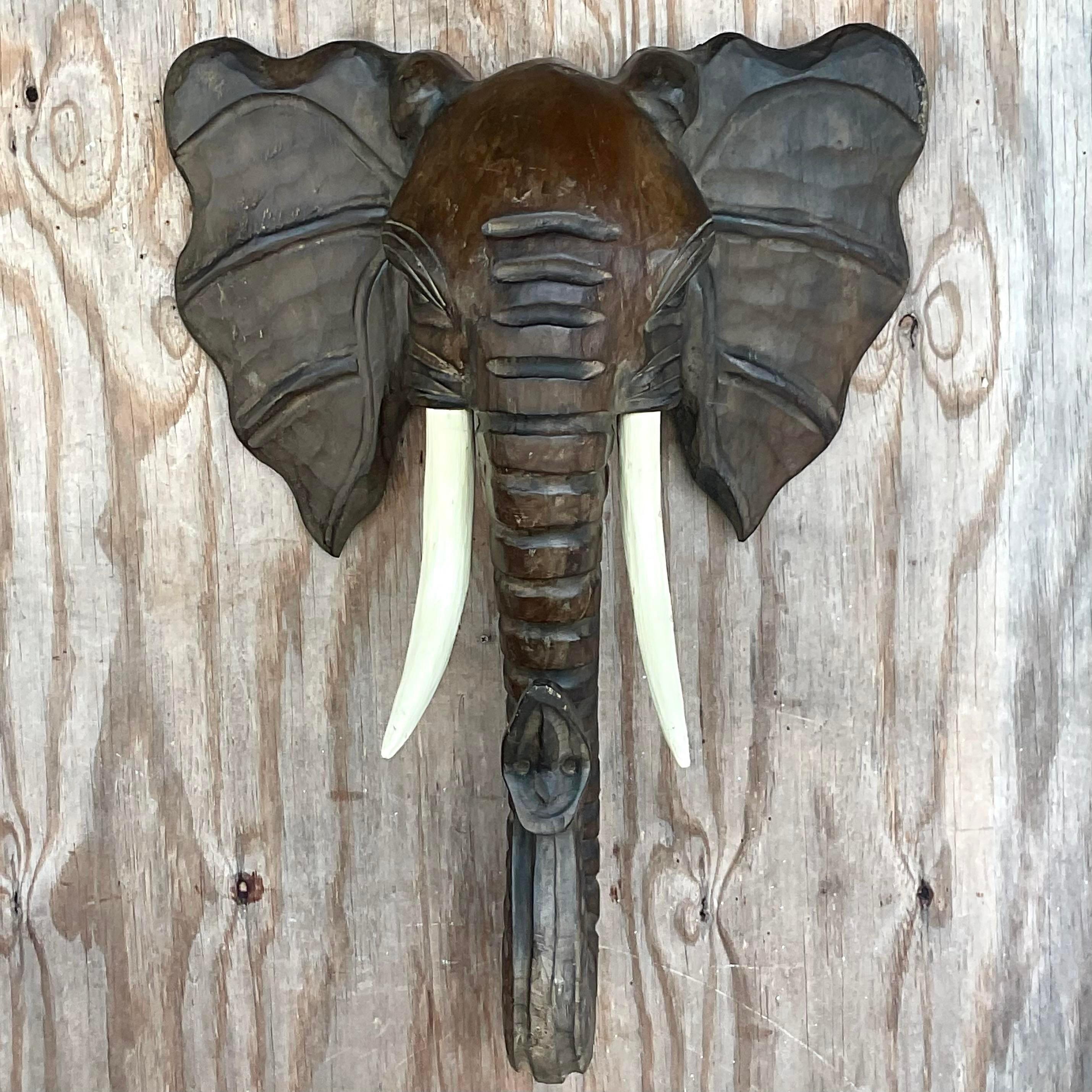 A fabulous vintage Boho wall sculpture. A chic hand carved elephant with impressive tusks. Monumental in size and drama. Acquired from a Palm Beach estate. 