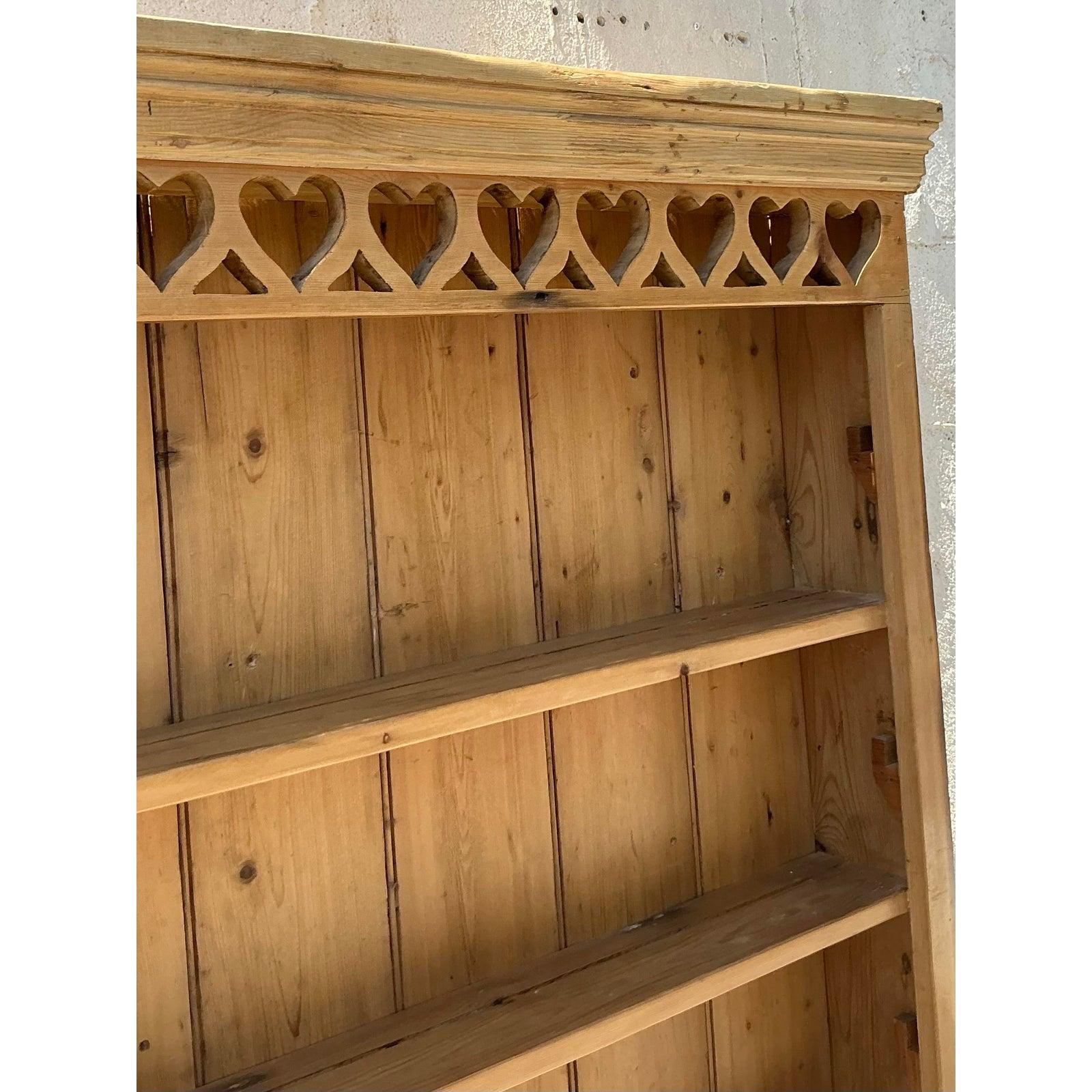 Add a touch of rustic romance to your space with this charming Vintage Boho Carved Heart Wall Shelf. Crafted from warm-toned pine, this unique piece features a delightful row of carved hearts along its top edge, adding a sweet and whimsical touch to