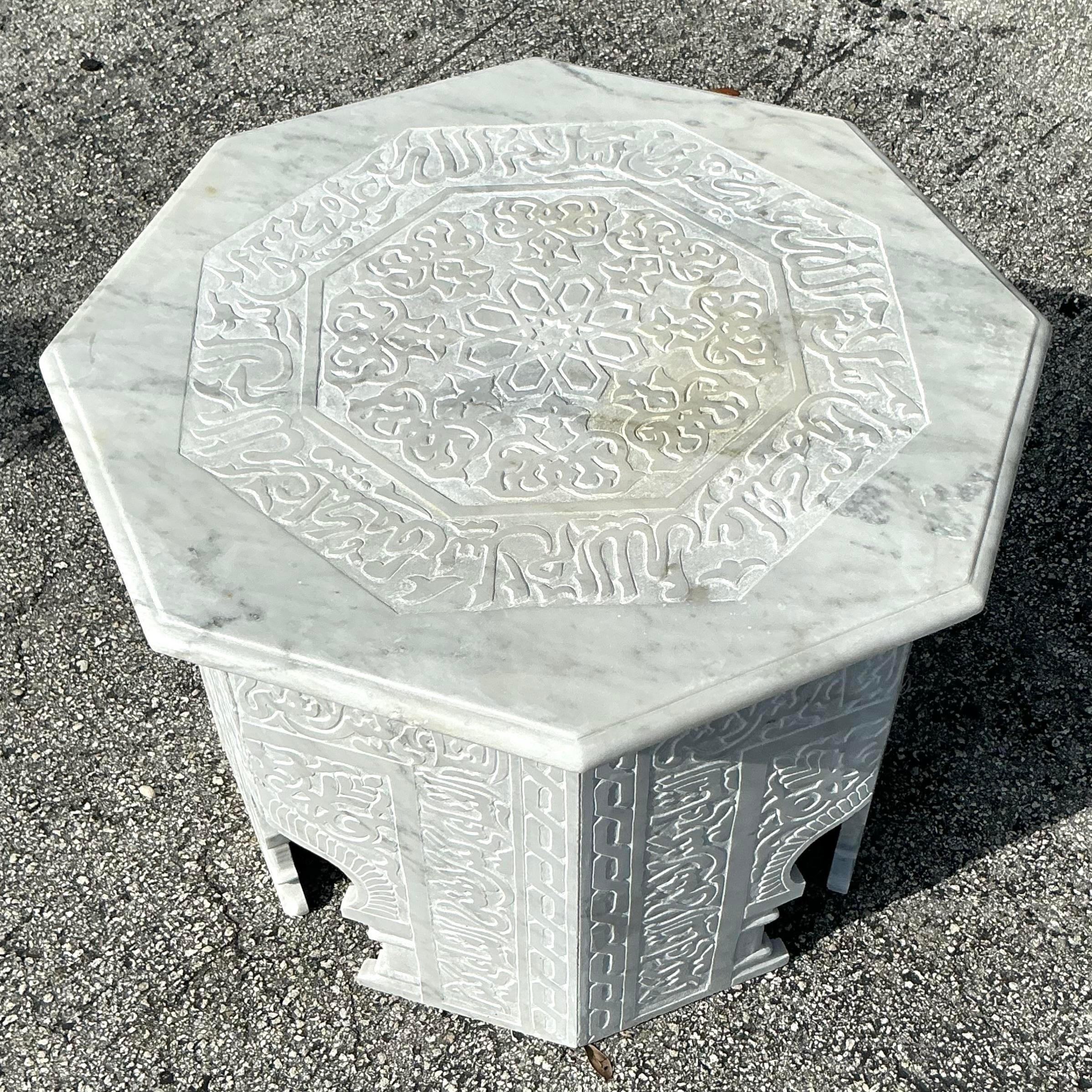 Bring global elegance into your home with this vintage boho carved marble Moroccan octagon side table. The hand-carved details and unique octagonal shape reflect authentic Moroccan artistry, while the marble top adds a touch of sophistication.