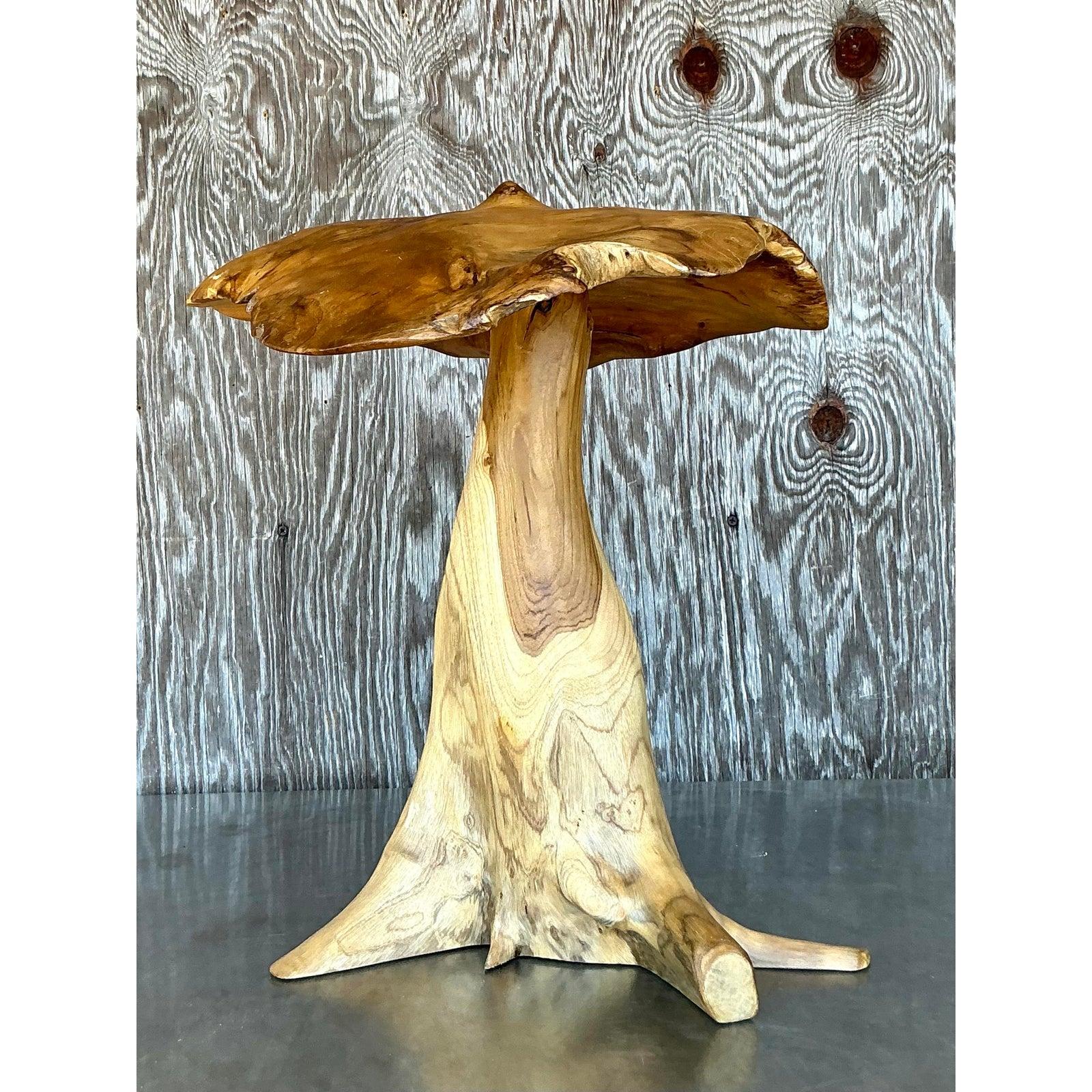 Dai un tocco di arte organica al tuo spazio con questo splendido tavolo vintage boho a fungo intagliato. Ricavata da un unico pezzo di legno naturale, la sua forma fluida e le ricche venature creano una scultura che incarna il fascino rustico e