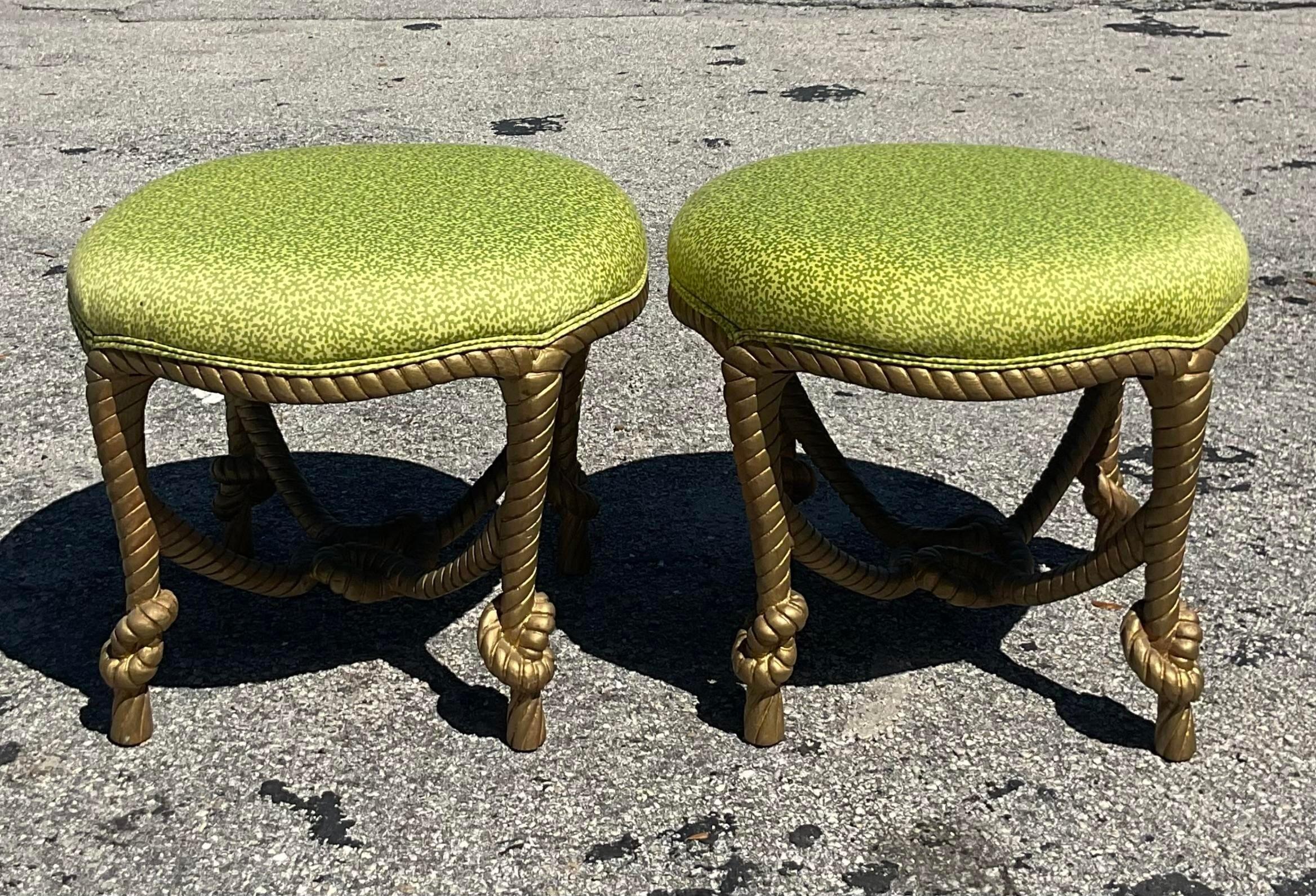 A stunning pair of vintage Boho low stools. A chic carved wood frame with a rope and knot design. Upholstered in a bright apple green floral. Acquired from a Palm Beach estate.