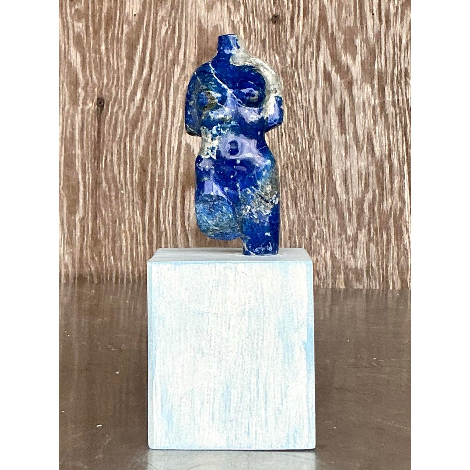 Celebra la belleza intemporal de la forma humana con esta llamativa escultura vintage de piedra tallada de un torso femenino. Realizada en cautivadores tonos azul oscuro con veteado jaspeado natural, esta pieza evoca una sensibilidad grecorromana