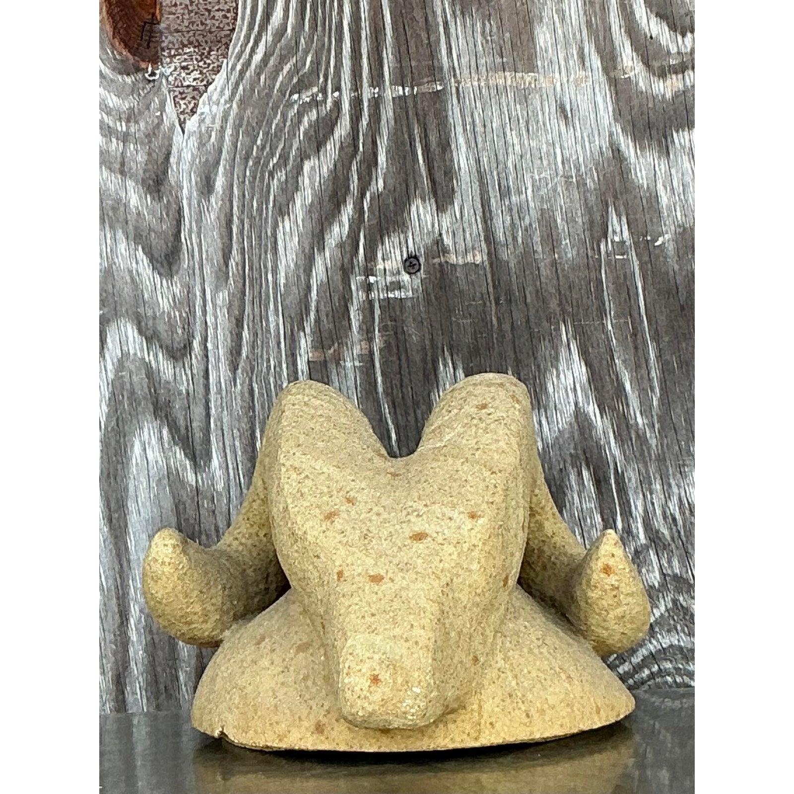 Terrestre e potente, questa scultura vintage in pietra boho scolpita a testa di ariete è uno studio sorprendente sulla forma organica e sul simbolismo primordiale. Scolpito a mano in pietra arenaria maculata, il design stilizzato è caratterizzato da