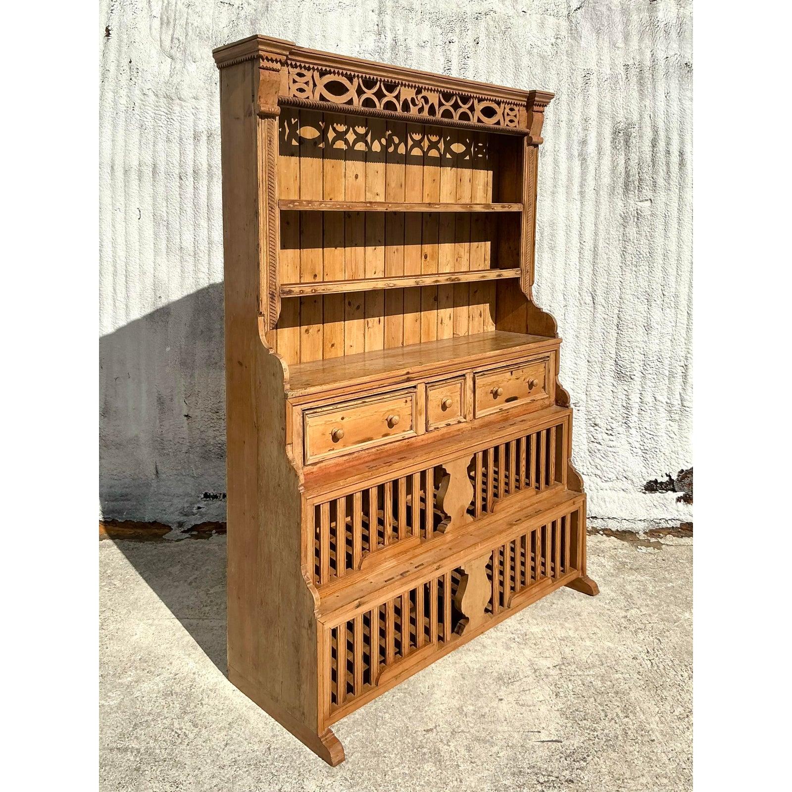 Transform your space with the rustic charm of this Vintage Boho Carved Storage Hutch, a beautifully crafted piece that exudes timeless character and bohemian allure. Handmade from solid pine, this hutch features intricate carved detailing along the