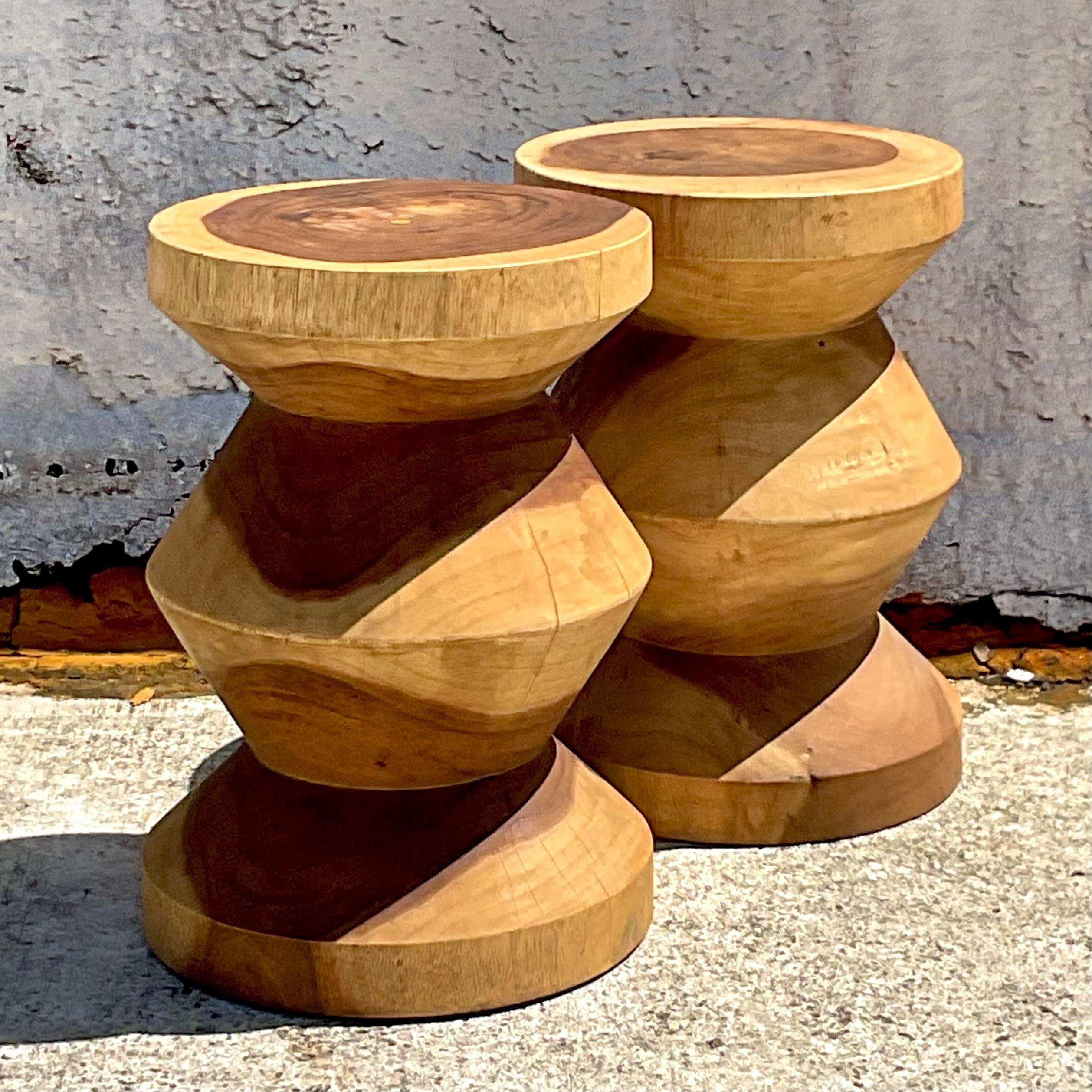 Elevate your decor with a touch of rustic elegance using this pair of vintage Boho carved stump low stools. Inspired by American craftsmanship and infused with Bohemian charm, these stools bring natural beauty and character to any space, blending