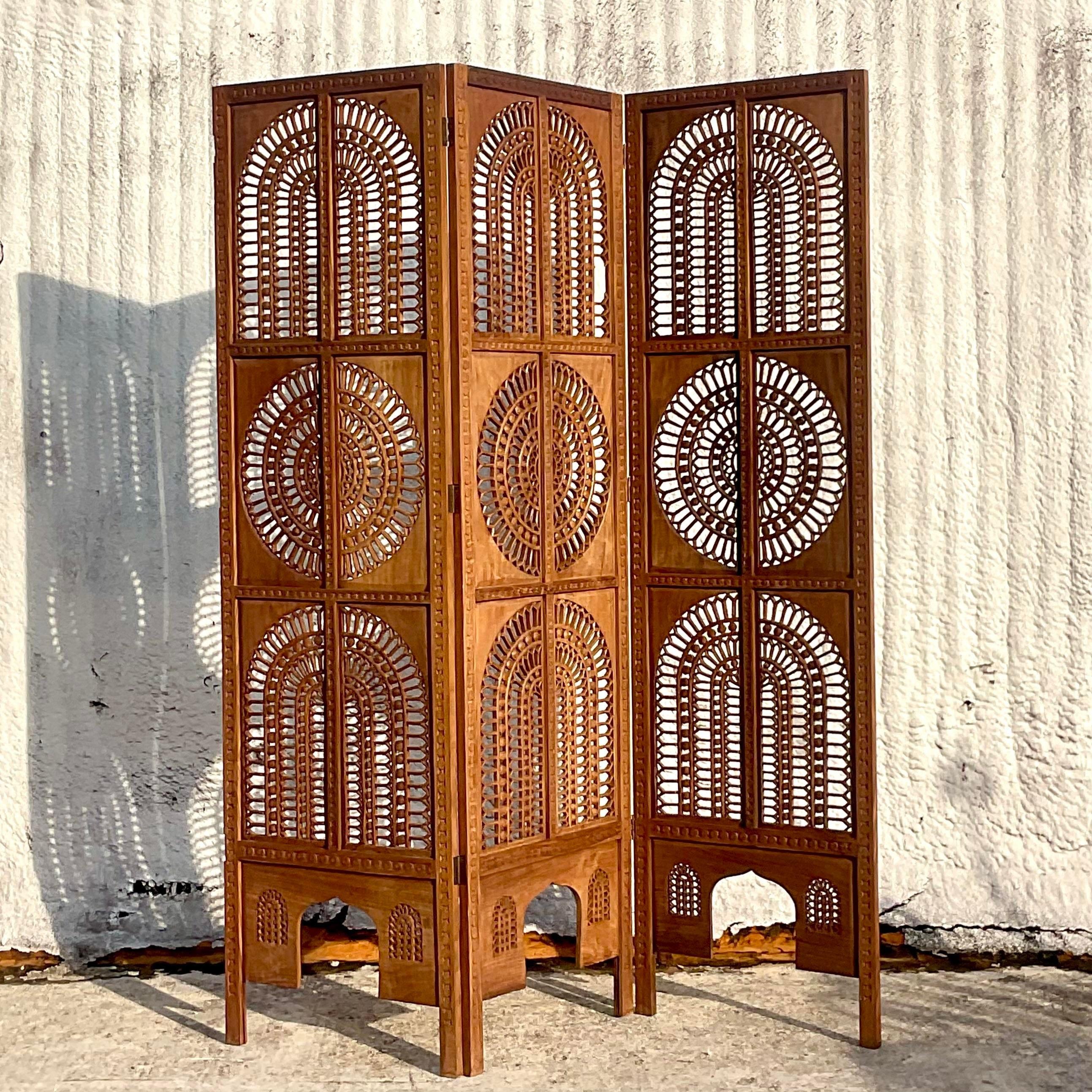 A stunning vintage Boho folding screen. A chic carved teak in a beautiful ring design. Acquired from a Palm Beach estate. 