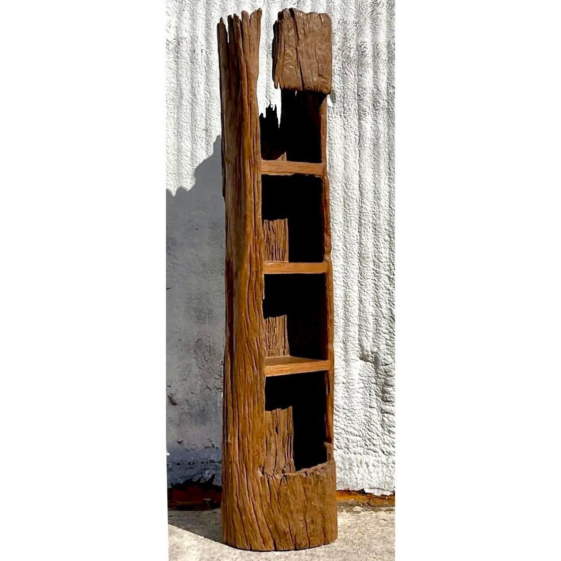 This remarkable vintage etagere, crafted from a beautifully carved tree trunk, embodies an authentic Boho aesthetic with a touch of organic modernism. The natural contours and rich texture of the wood are preserved, showcasing the raw beauty and
