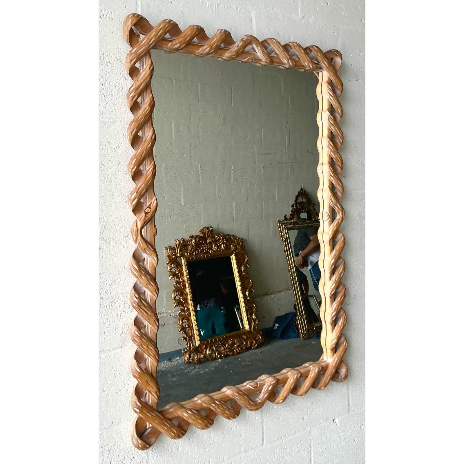 Abbraccia la bellezza dell'artigianato con questo affascinante specchio vintage in legno intagliato. La cornice è un'incredibile dimostrazione di abilità, caratterizzata da un design a intreccio continuo e aperto che evoca la trama della corda