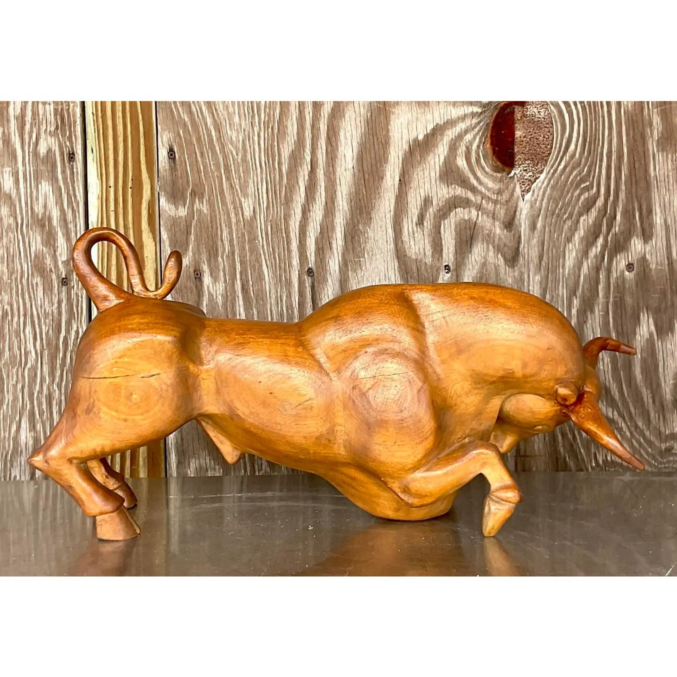 A chic hand carved wood bull sculpture. Beautiful wood grain detail with a beautiful patina from time. Acquired from a Palm Beach estate.
