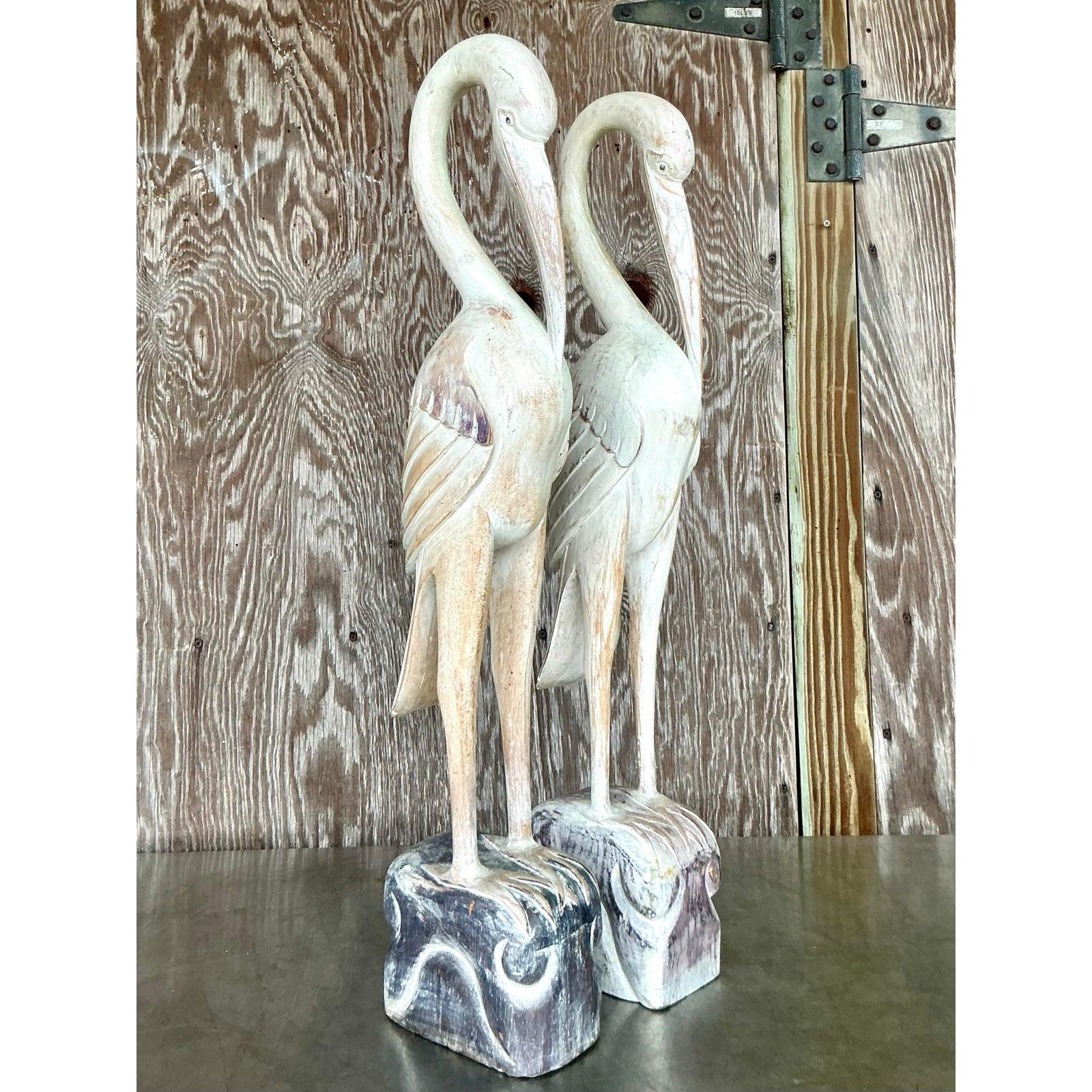 Valorizza il tuo spazio con questa splendida coppia di statue di gru in legno intagliato in stile boho vintage. Questi eleganti uccelli sono caratterizzati da colli graziosamente arcuati e da un piumaggio finemente dettagliato, che mette in mostra