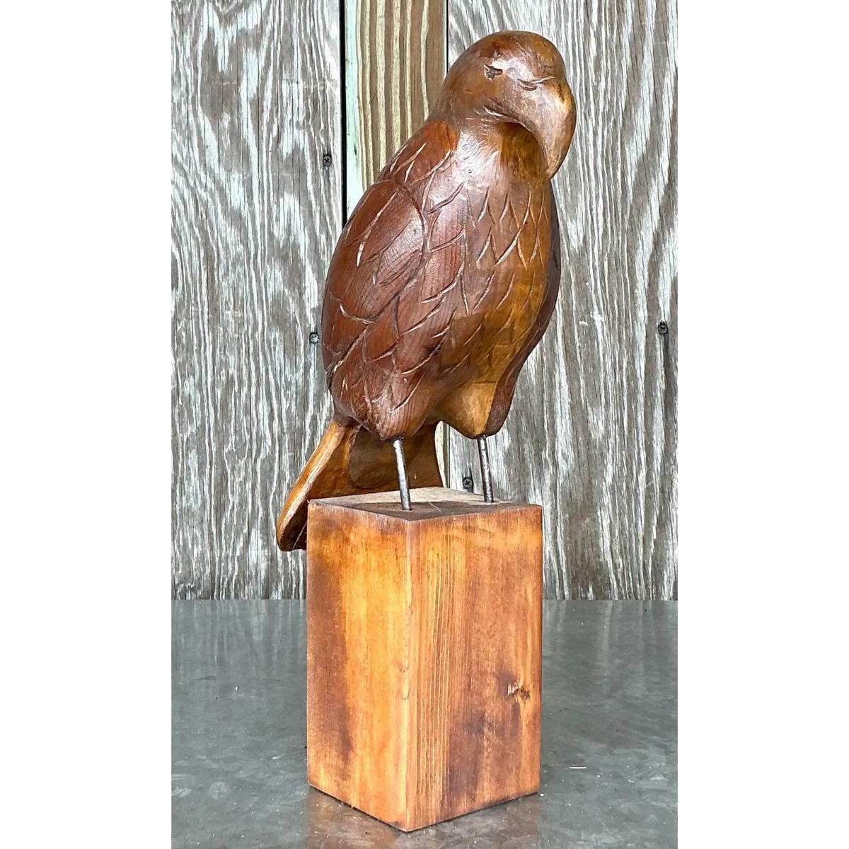 Questa splendida aquila vintage in legno intagliato è un esempio straordinario di arte artigianale. Con la sua posa maestosa e gli intagli dettagliati delle piume, l'aquila è alta 15,5 pollici e poggia su una robusta base di legno. I ricchi toni e