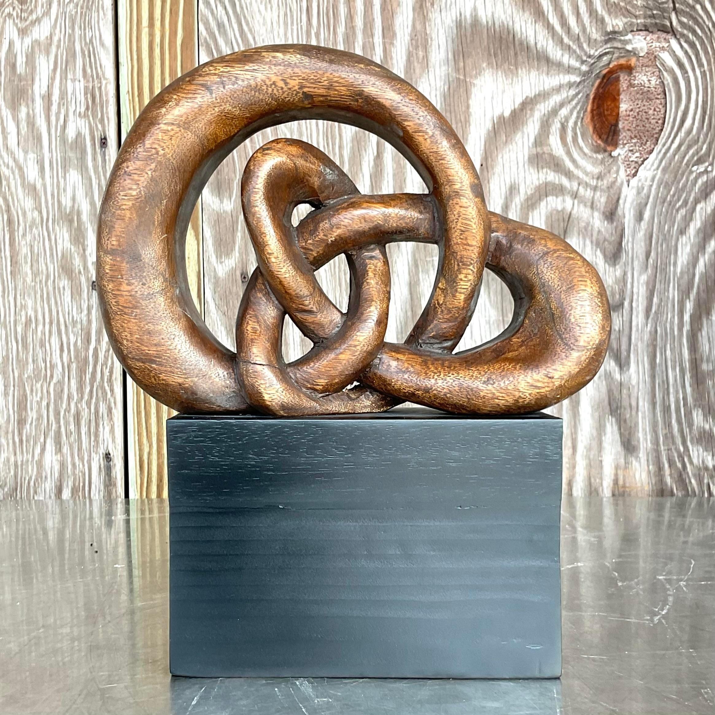 Infuse your space with a dash of free-spirited charm and heartfelt sentiment. This vintage boho carved wood love knot sculpture exudes rustic elegance and timeless appeal. Crafted with intricate detailing, it serves as a symbol of everlasting love