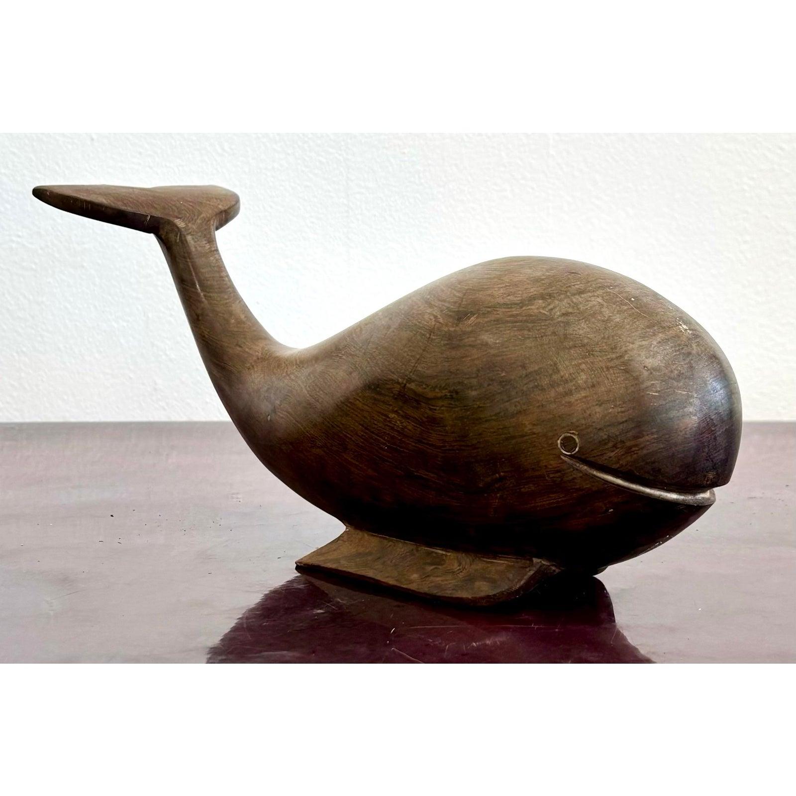 Questa incantevole scultura di balena in legno dona un tocco di estrosità e calore a qualsiasi spazio. Scolpito con un corpo arrotondato e una coda sollevata, irradia un'atmosfera giocosa e moderna di metà secolo. La dolce curva della bocca e il