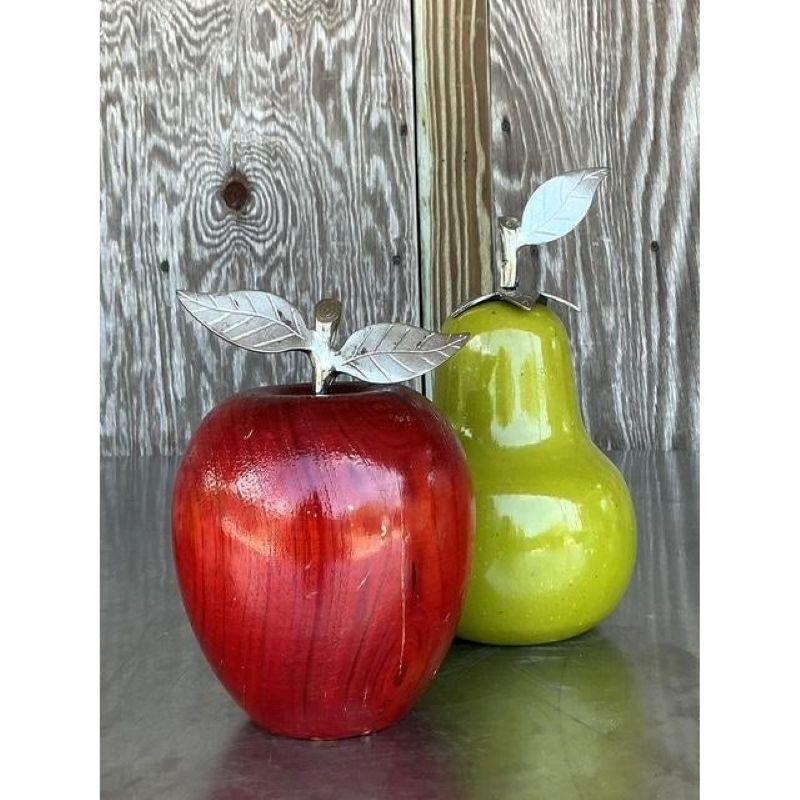 Cattura il fascino vibrante del design del Mid-Century con questa deliziosa coppia di sculture decorative di frutta. Questo set comprende una mela rosso rubino e una pera verde lime, tutte intagliate a mano nel legno e rifinite con una vernice