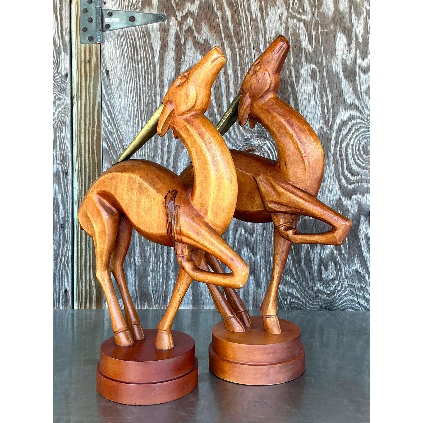 Introduci un tocco di stile elegante e vintage nella tua casa con questa affascinante scultura di gazzella in legno intagliata a mano. La sua forma allungata e aggraziata e la sua posa dinamica evocano l'eleganza della sensibilità del design del