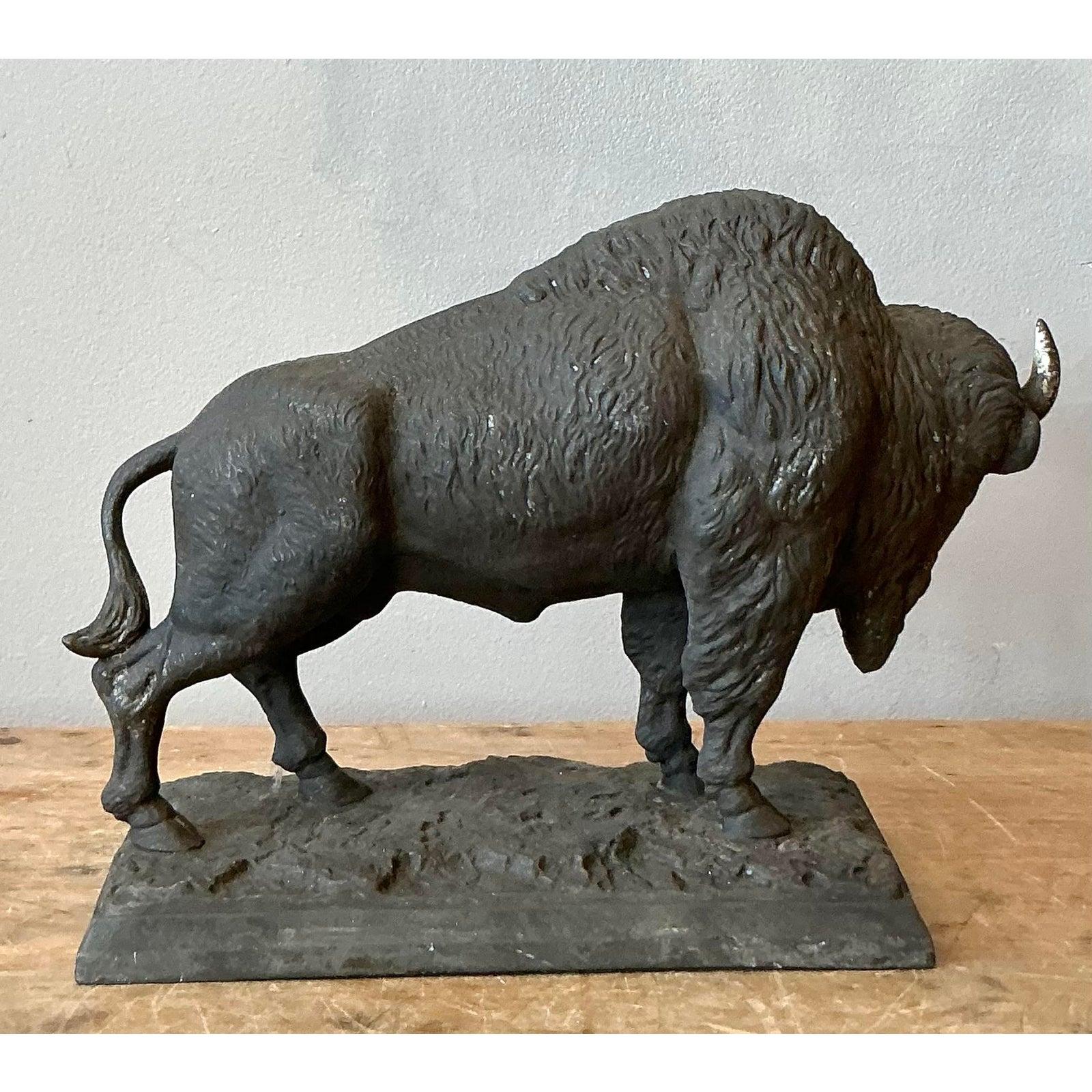 Questa potente scultura d'epoca raffigura un magnifico bisonte americano in una posa sorprendente e dettagliata. Fuso in metallo pesante, probabilmente ferro o spelta rifinita in bronzo, il pezzo presenta notevoli dettagli testuali che simulano il
