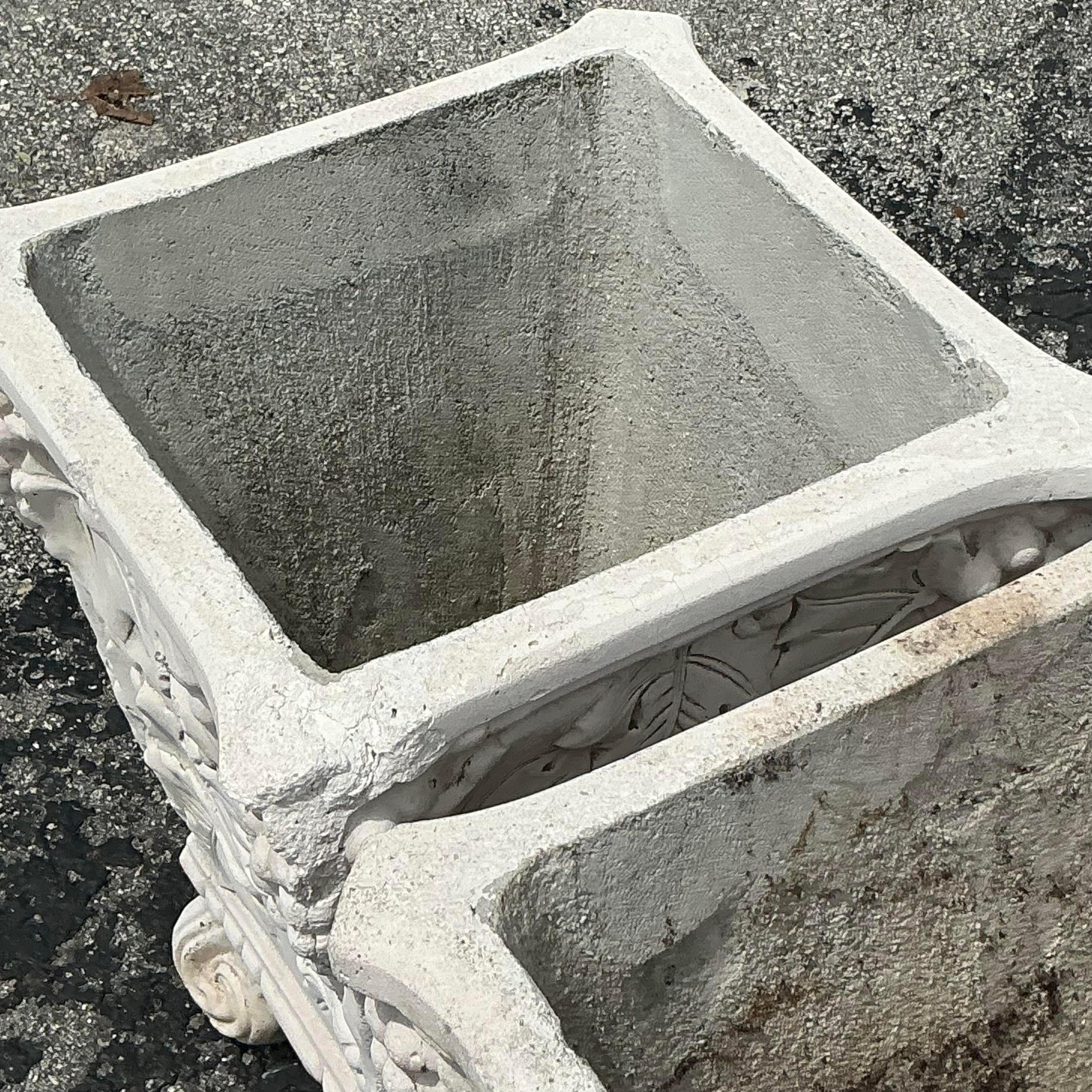 This pair of vintage Boho cast concrete grape vine planters features intricate vine detailing, perfect for adding a rustic, organic charm to your garden or patio. Acquired from a Palm Beach estate