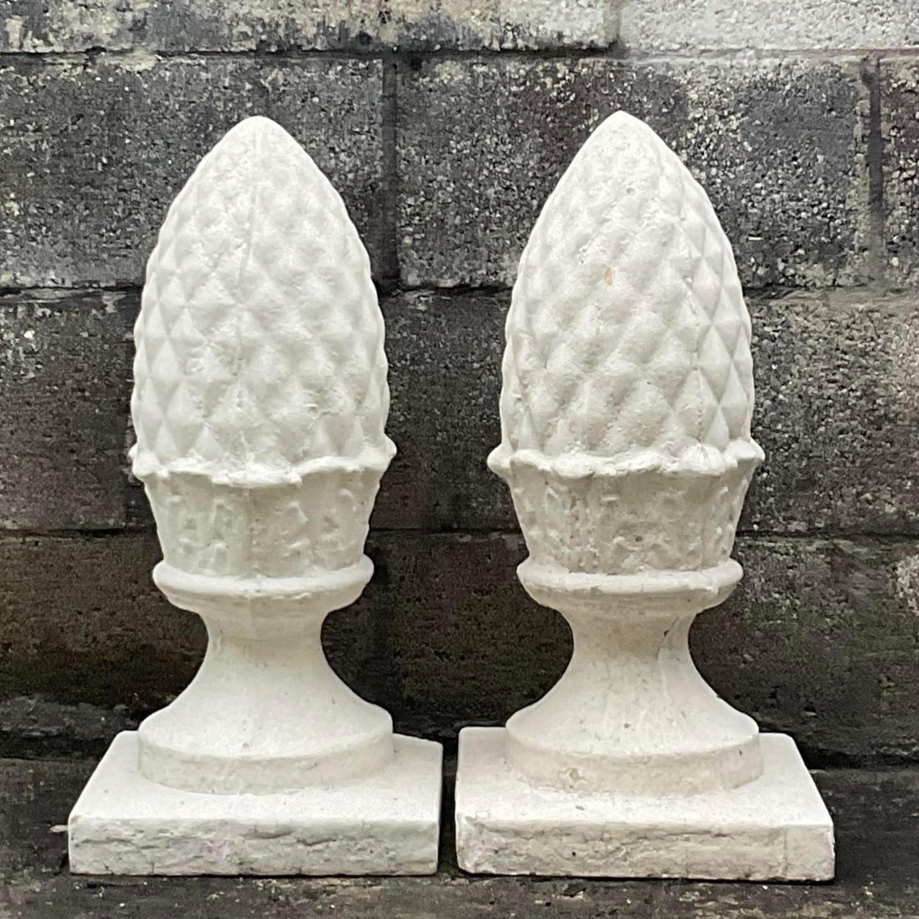 A fabulous pair of vintage outdoor sculptures. Chic cast concrete pineapples in a distressed white finish. Perfect indoors or outside. Acquired from a Palm Beach estate.