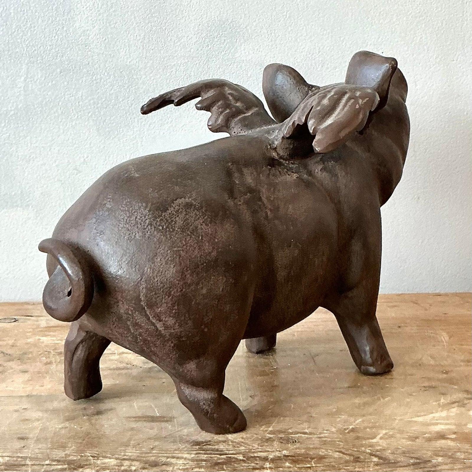 Ti presentiamo un'affascinante scultura di maiale volante in ghisa vintage, un pezzo stravagante e caratteristico che promette di aggiungere carattere a qualsiasi spazio. Questo delizioso pezzo incarna uno spirito giocoso, fondendo un'estetica