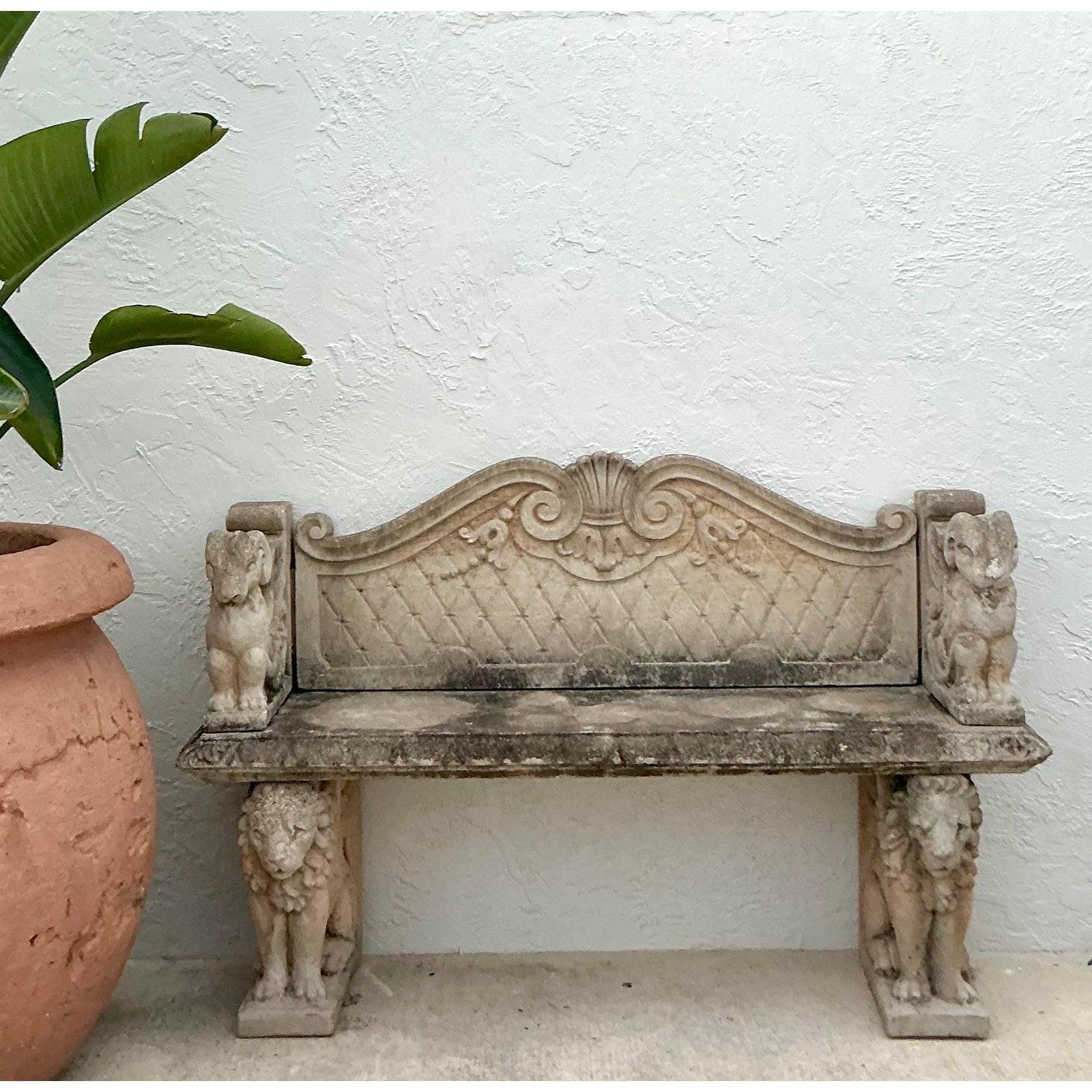 Infuse your garden or entryway with the grandeur of a European villa with this magnificent vintage cast stone bench. This is no mere seat; it is a piece of sculptural art, designed to command attention. The bench is supported by a pair of stately,