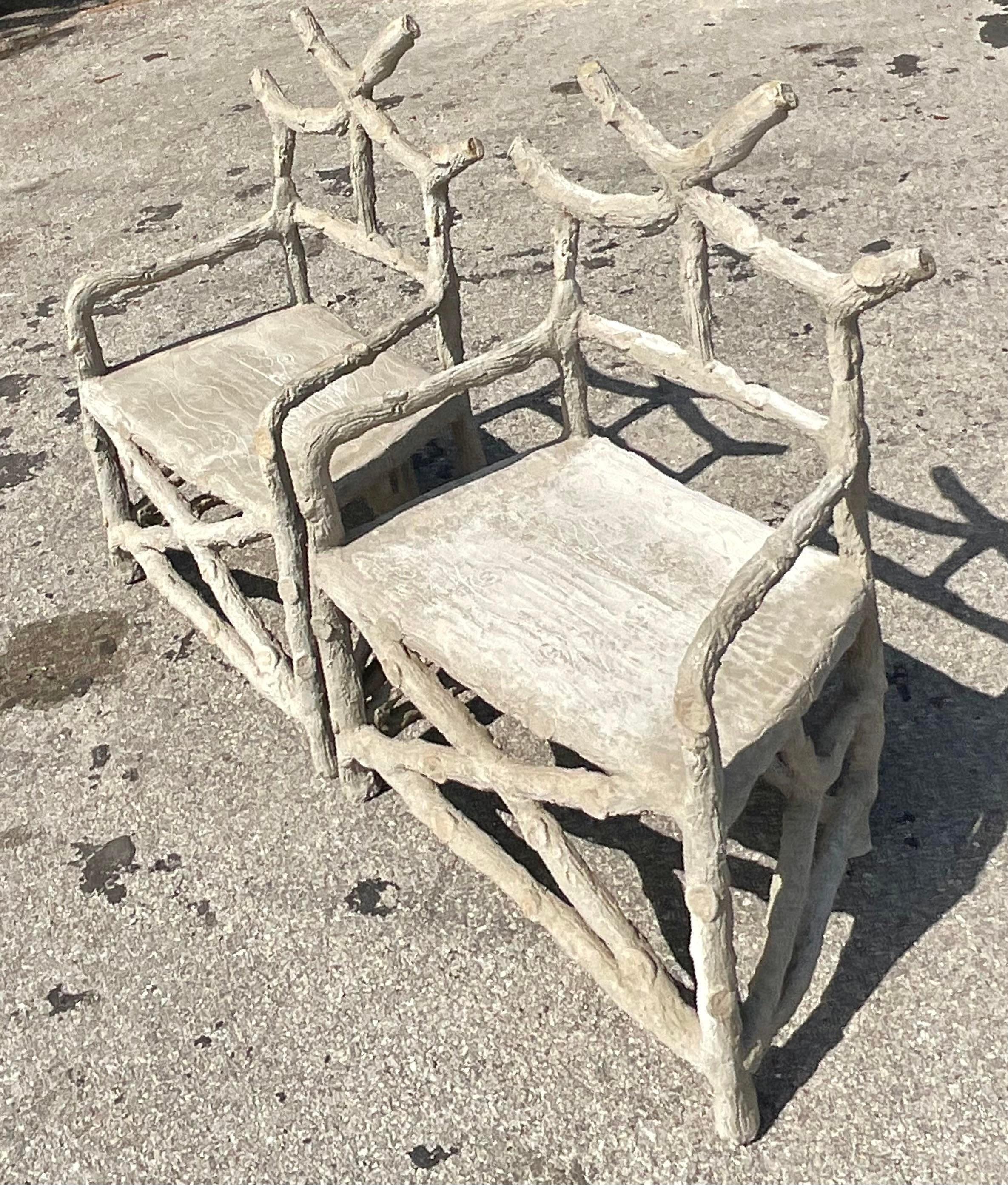 A spectacular pair of vintage lounge chairs. A chic Faux Bois branch design in a cement gray finish. A real pair of showstoppers. Perfect to take any space to the next level. Acquired from a Palm Beach estate.