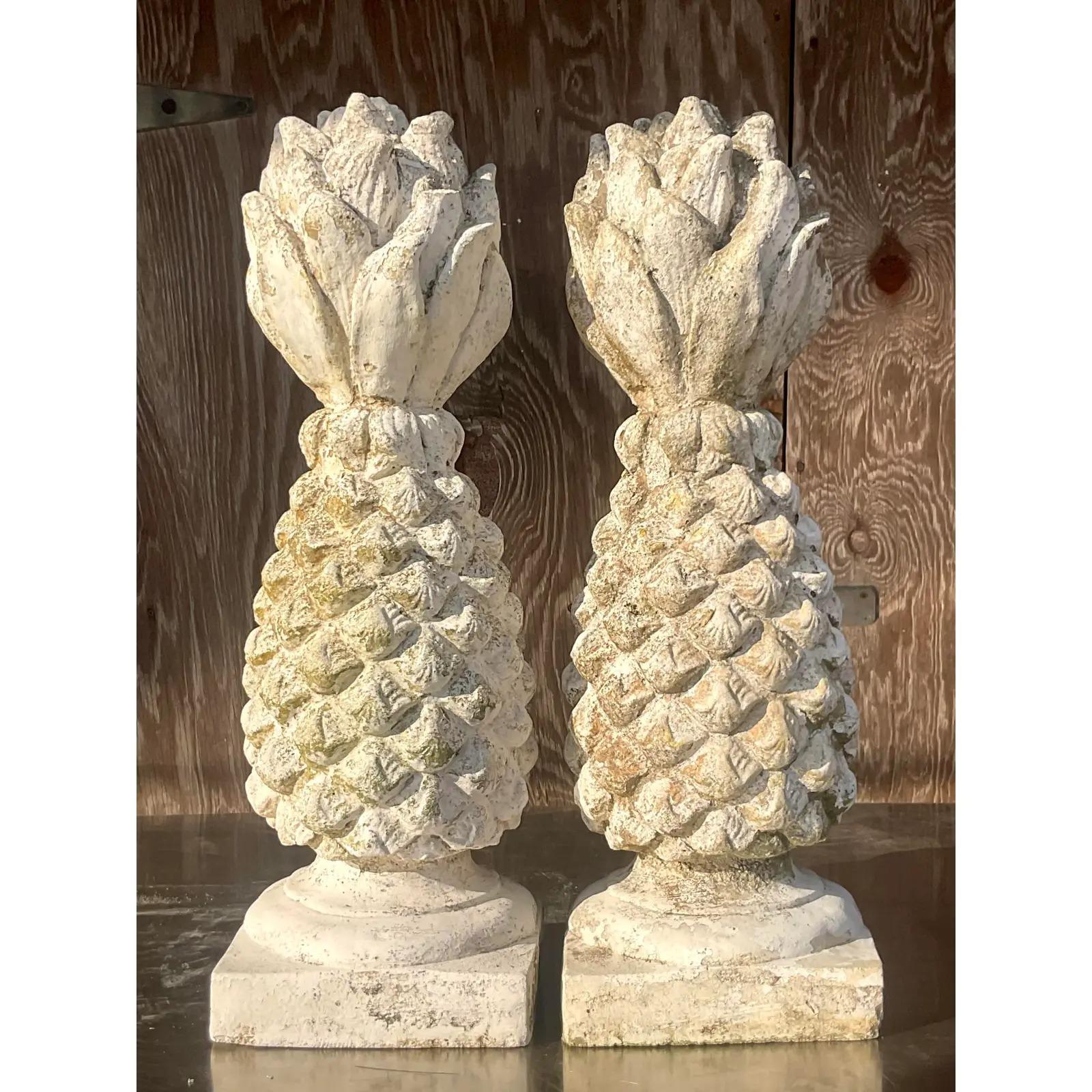 A fabulous pair of vintage cement garden ornaments. A chic pair of vintage pineapples with an all over patina from time. Acquired from a Palm Beach estate.