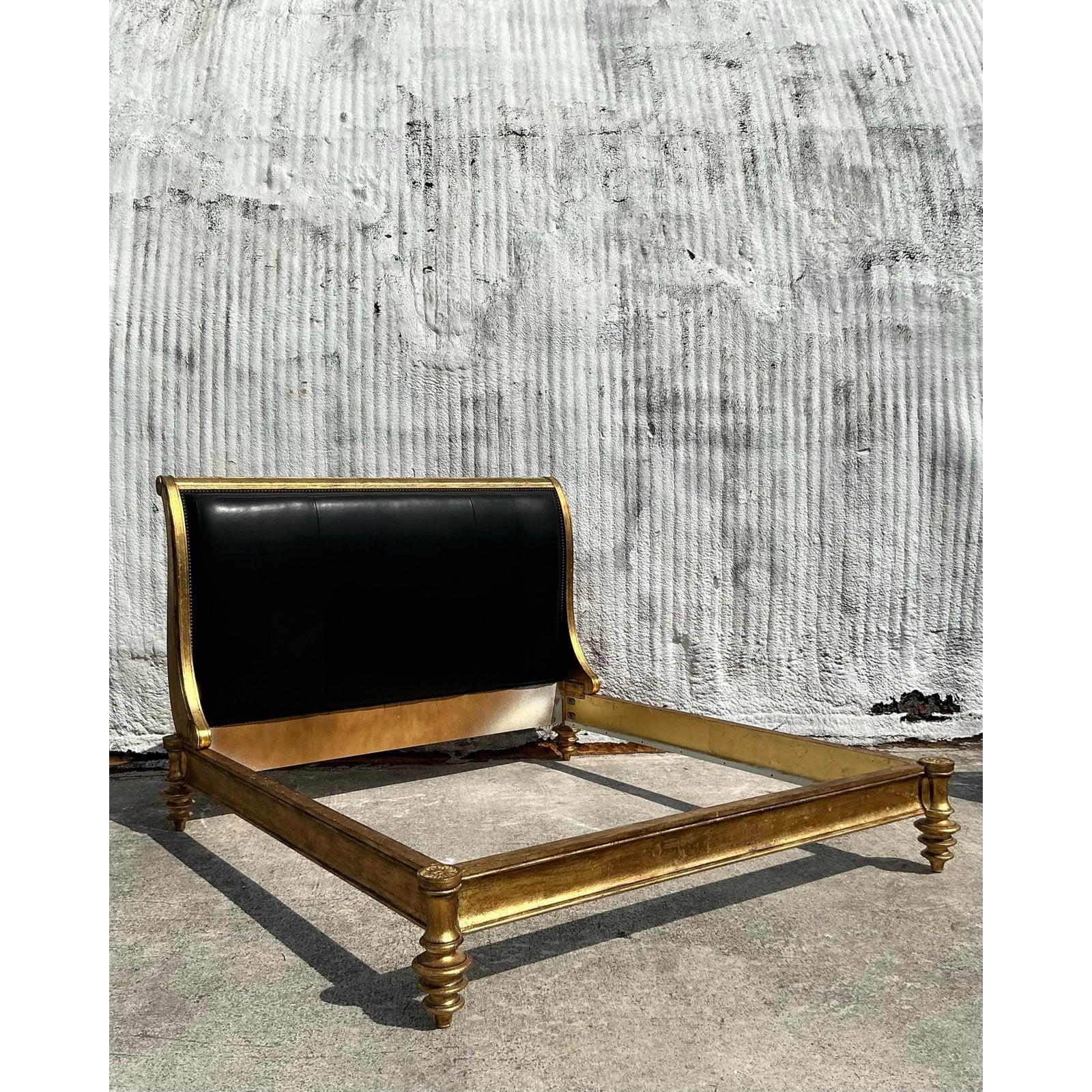 Make a grand statement with this vintage gilded wood and leather king bedframe, an exquisite fusion of elegance and craftsmanship. The rich, hand-carved wooden frame is finished in a luxurious gold gilt, giving it a regal presence that exudes