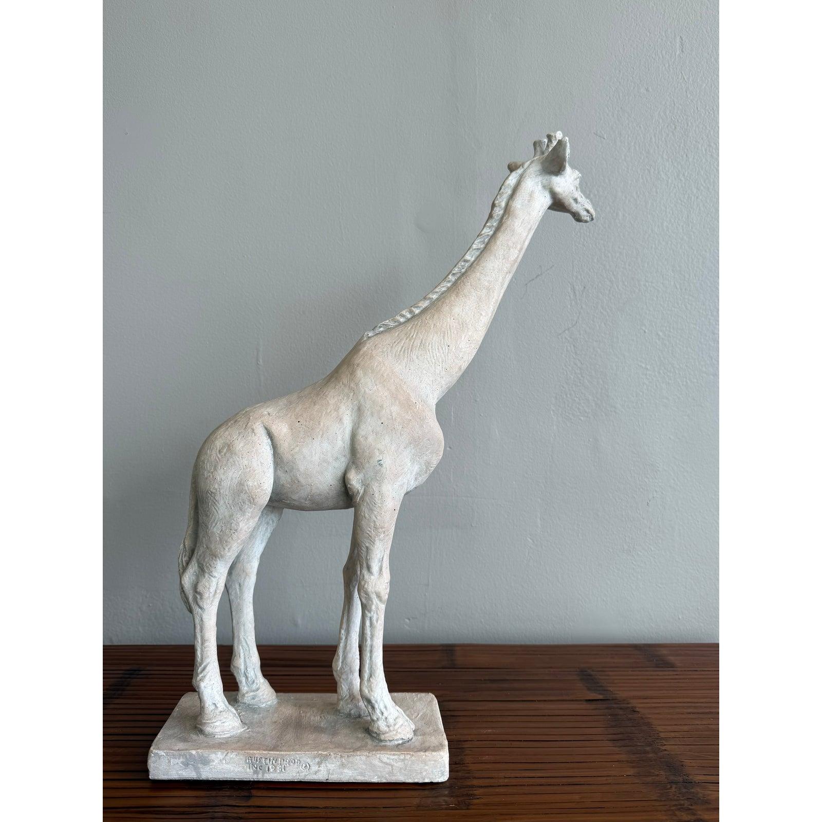 Eleganza con questa scultura di giraffa elegante e curata nei minimi dettagli. Realizzato con una finitura bianca e gessosa con una sottile patina, il pezzo bilancia dettagli anatomici realistici con una forma leggermente stilizzata. Il suo collo