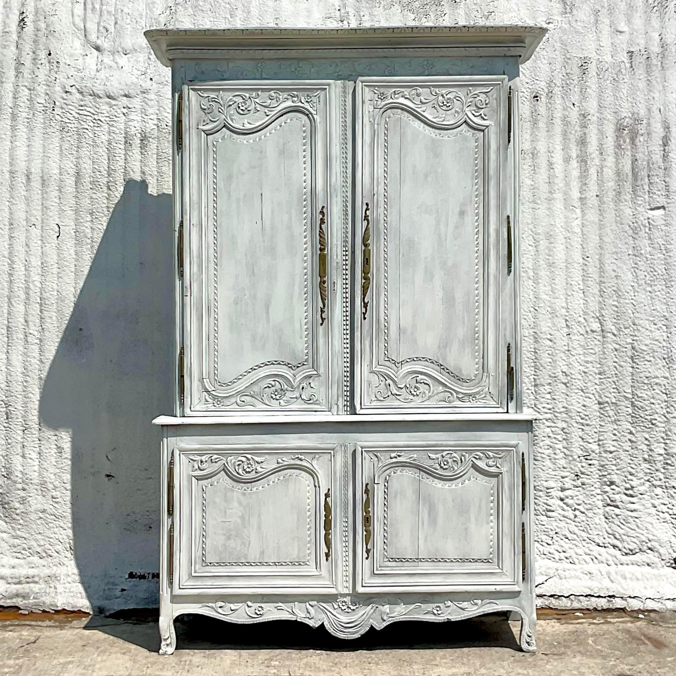 A spectacular vintage Boho storage cabinet. A stunning French cabinet with hand carved detail and a cerused finish. Lots of great storage space above and below. Acquired from a Palm Beach estate.