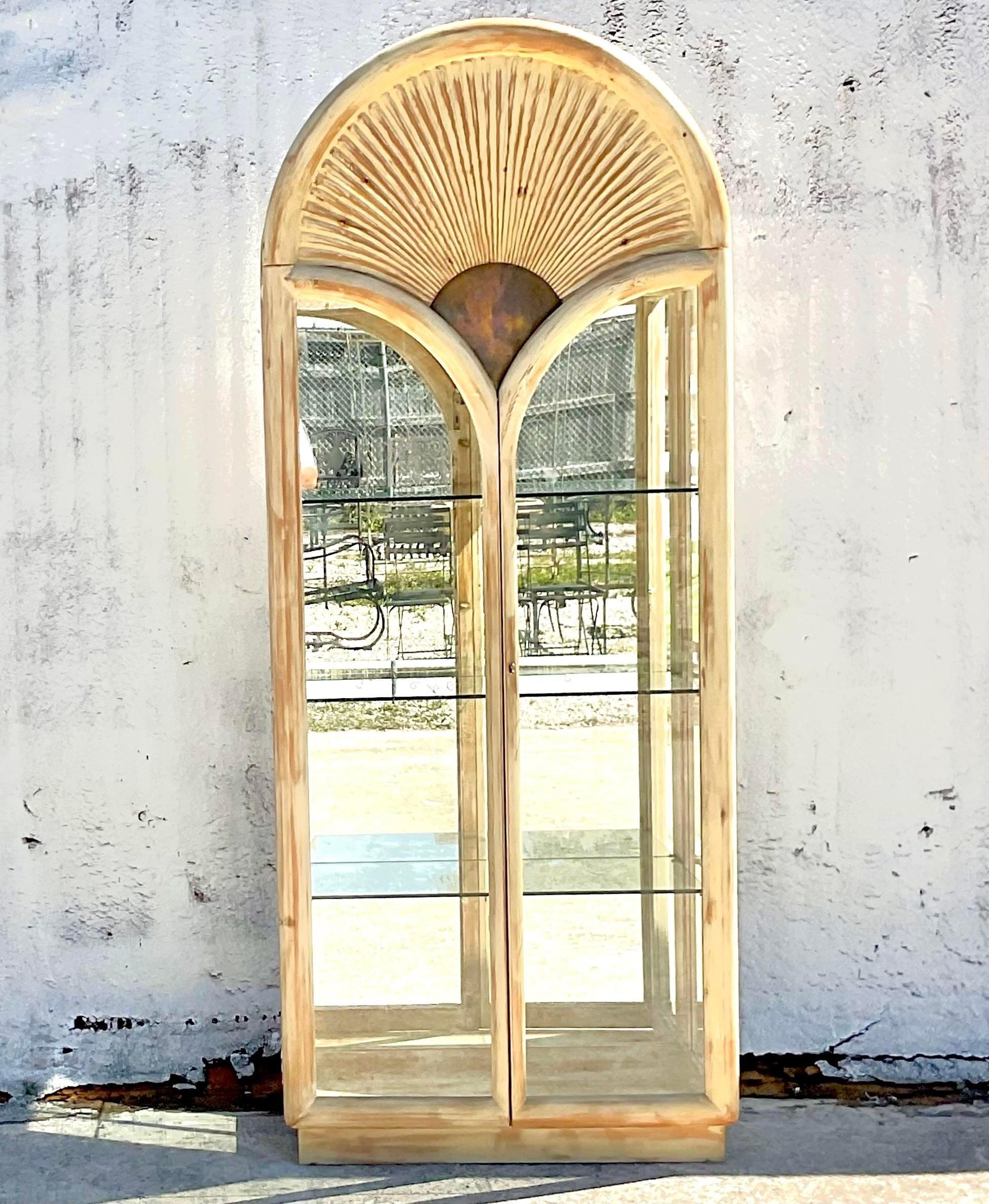 An extraordinary vintage Boho arched etagere. Beautiful cerused pine frame with a mirrored back, brass flashing and glass shelving. Super glamorous. Acquired from a Palm Beach estate.