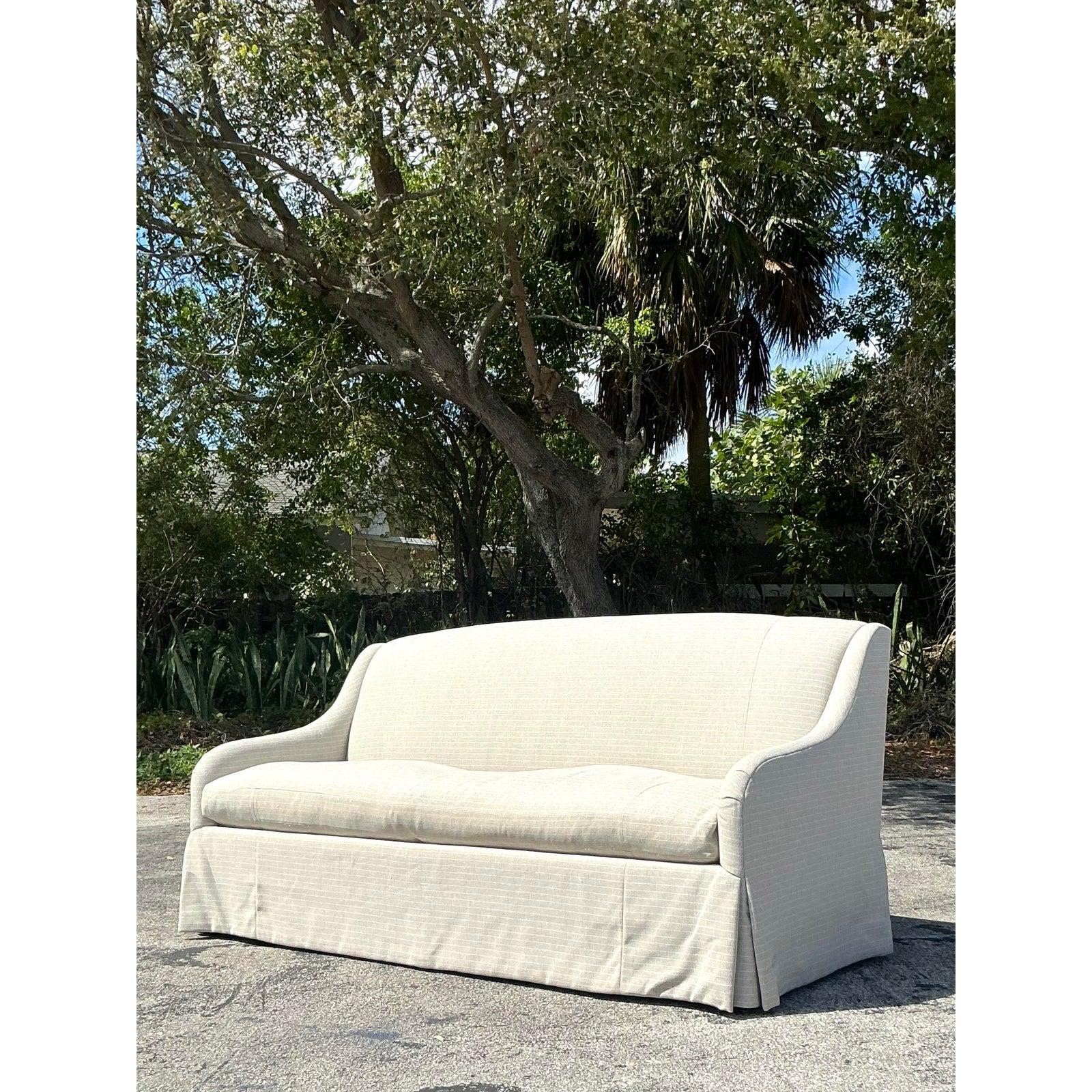 Cet élégant canapé Charles Stewart dégage un charme bohème raffiné avec son tissu à rayures subtiles et sa silhouette gracieusement incurvée. Sa base à jupe sur mesure et son coussin moelleux apportent à la fois sophistication et confort, ce qui en
