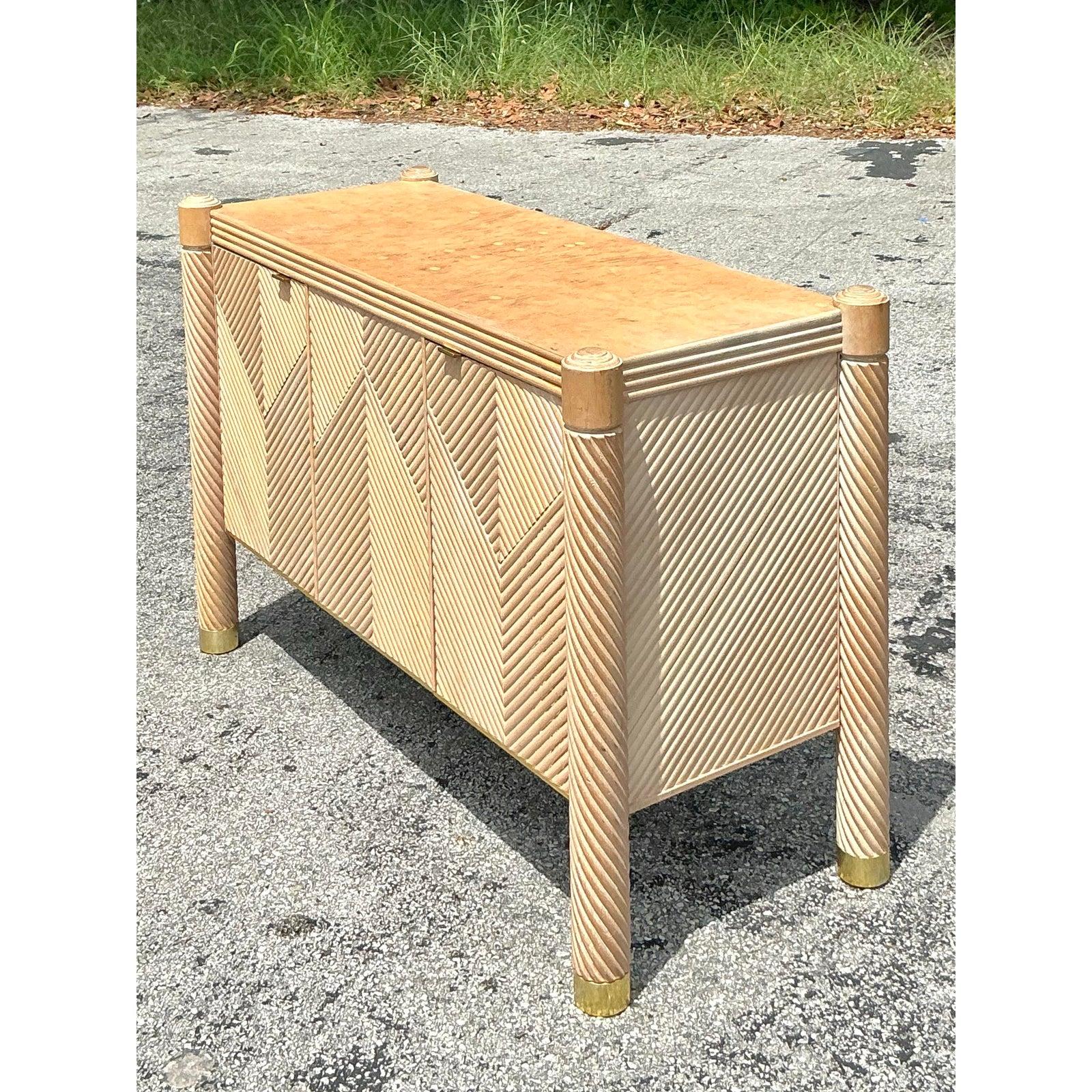 Infunde a tu espacio el encanto cautivador y la riqueza de texturas de esta Credenza Vintage Boho Chevron de ratán. Una pieza llamativa que combina a la perfección la geometría inspirada en el Art Déco con una sensibilidad orgánica y relajada. Los
