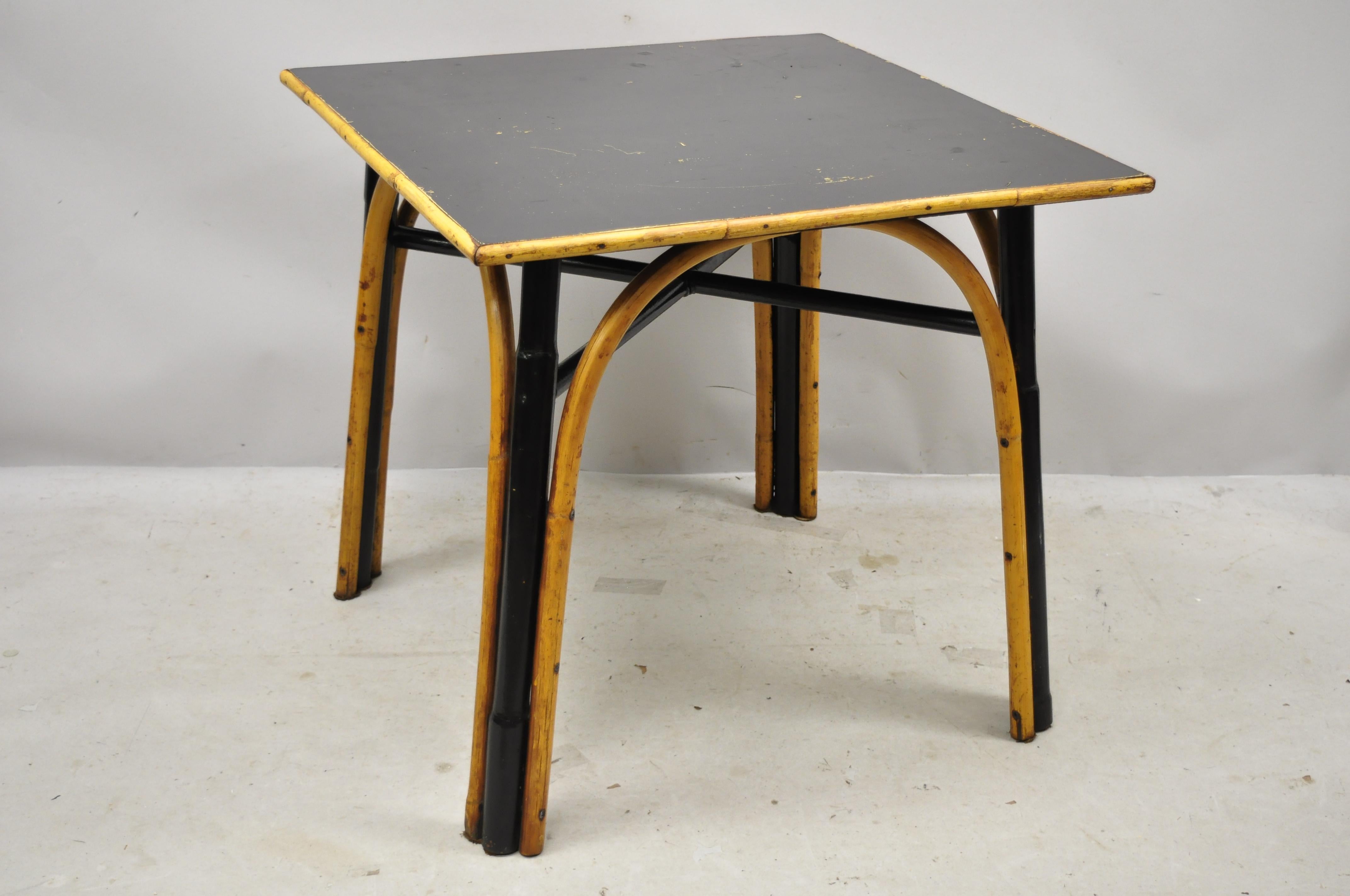 Vintage boho chic bentwood bamboo square card game table wicker dining table. Item features bent bamboo legs and base, black mica top, stretcher base, very nice vintage item, great style and form, circa mid-20th century.
Measurements: 28.5