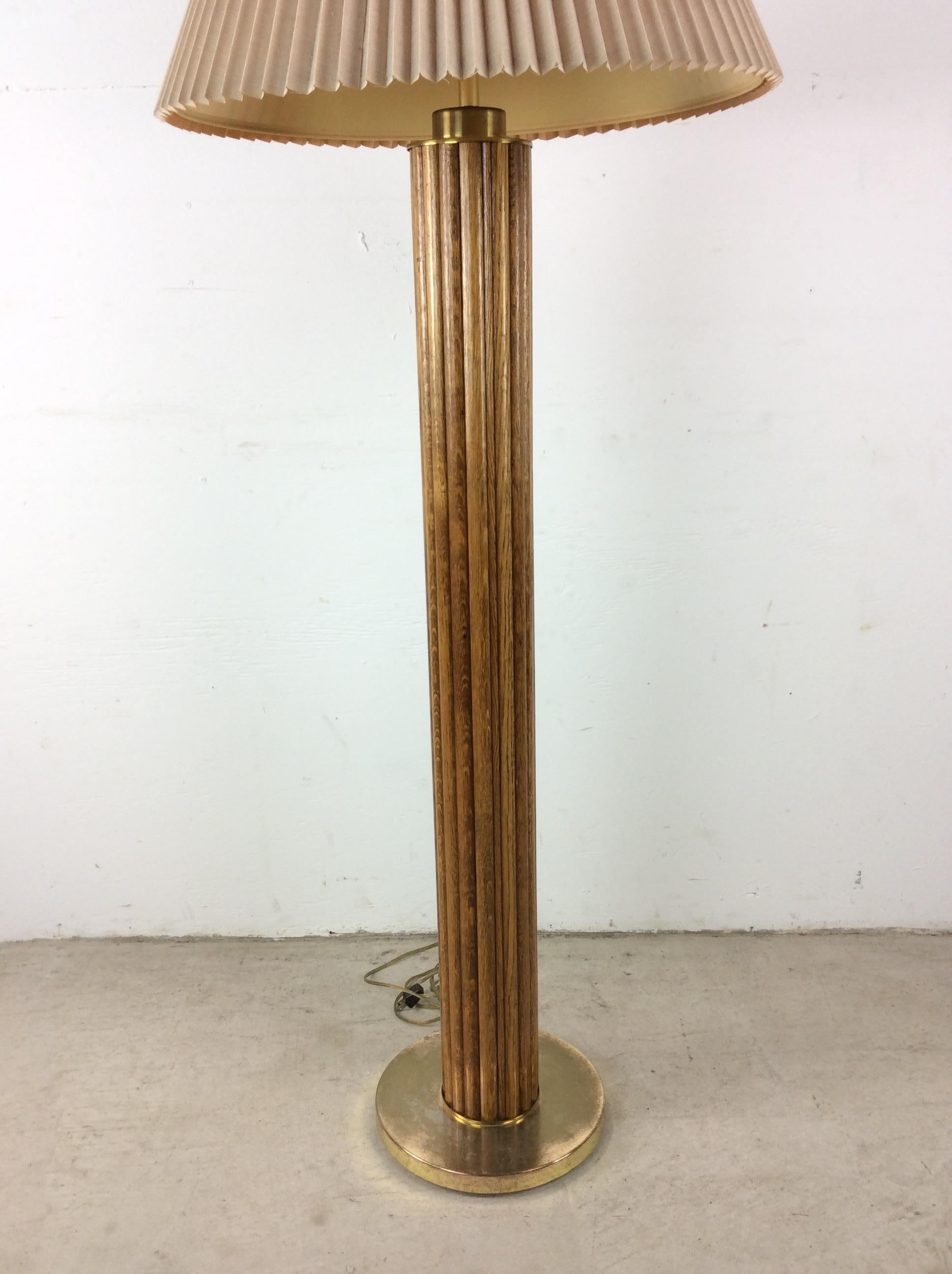 This vintage floor Bohemian style lamp features beautiful oak stained rattan body with brass accented base and pleated shade.  Measurements are with shade included. Base measures 11w 11d 59h

Dimensions: 21w 21d 59h

Condition: Vintage wiring is