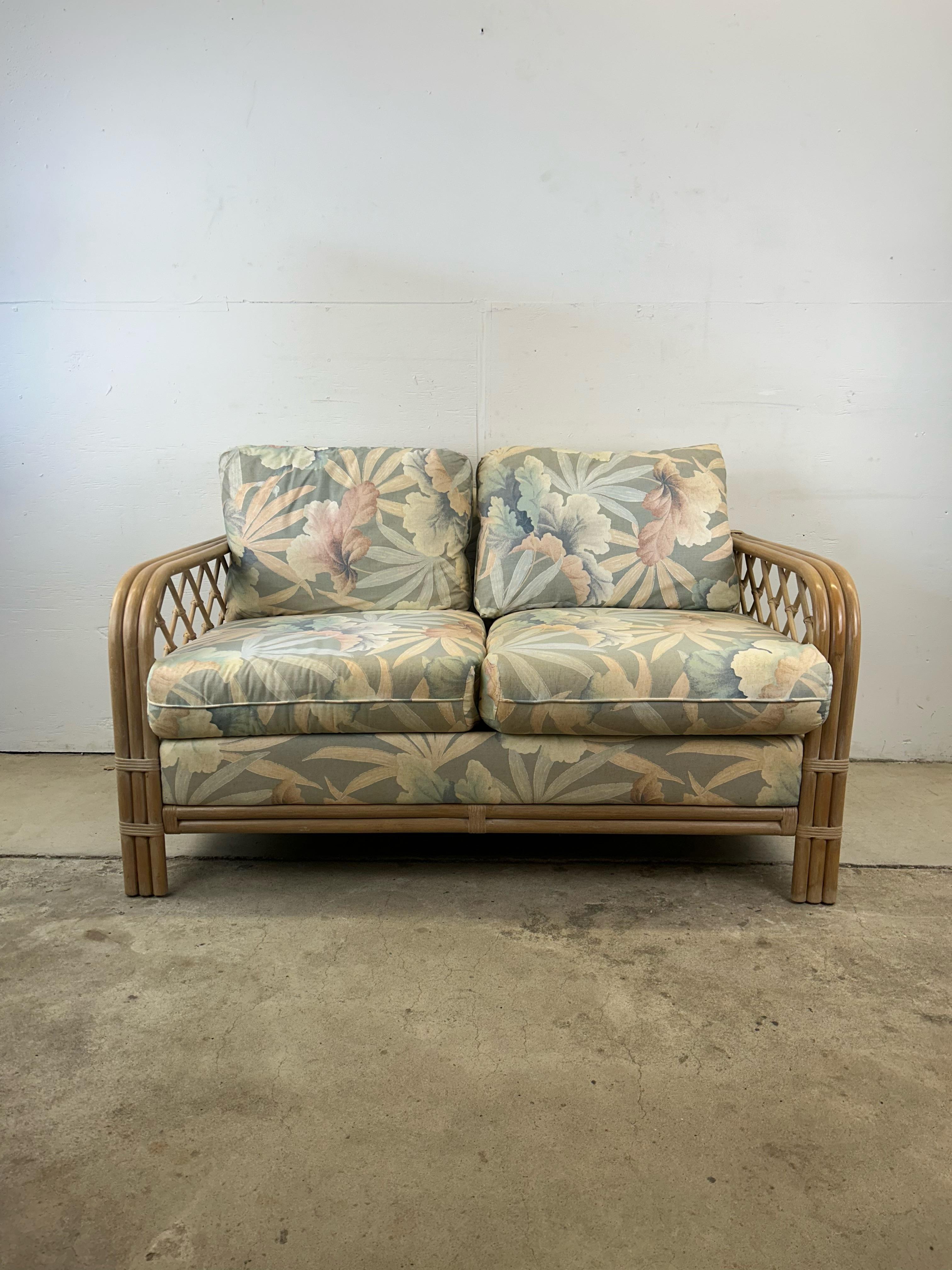 Dieses Vintage-Liebesofa verfügt über einen weiß gewaschenen Rattanrahmen mit Armlehnen aus Bugholz und abnehmbare Kissen mit originaler Blumenpolsterung. 

Das passende dreisitzige Sofa ist separat erhältlich.  

Abmessungen: 55b 34d 32h 20sh