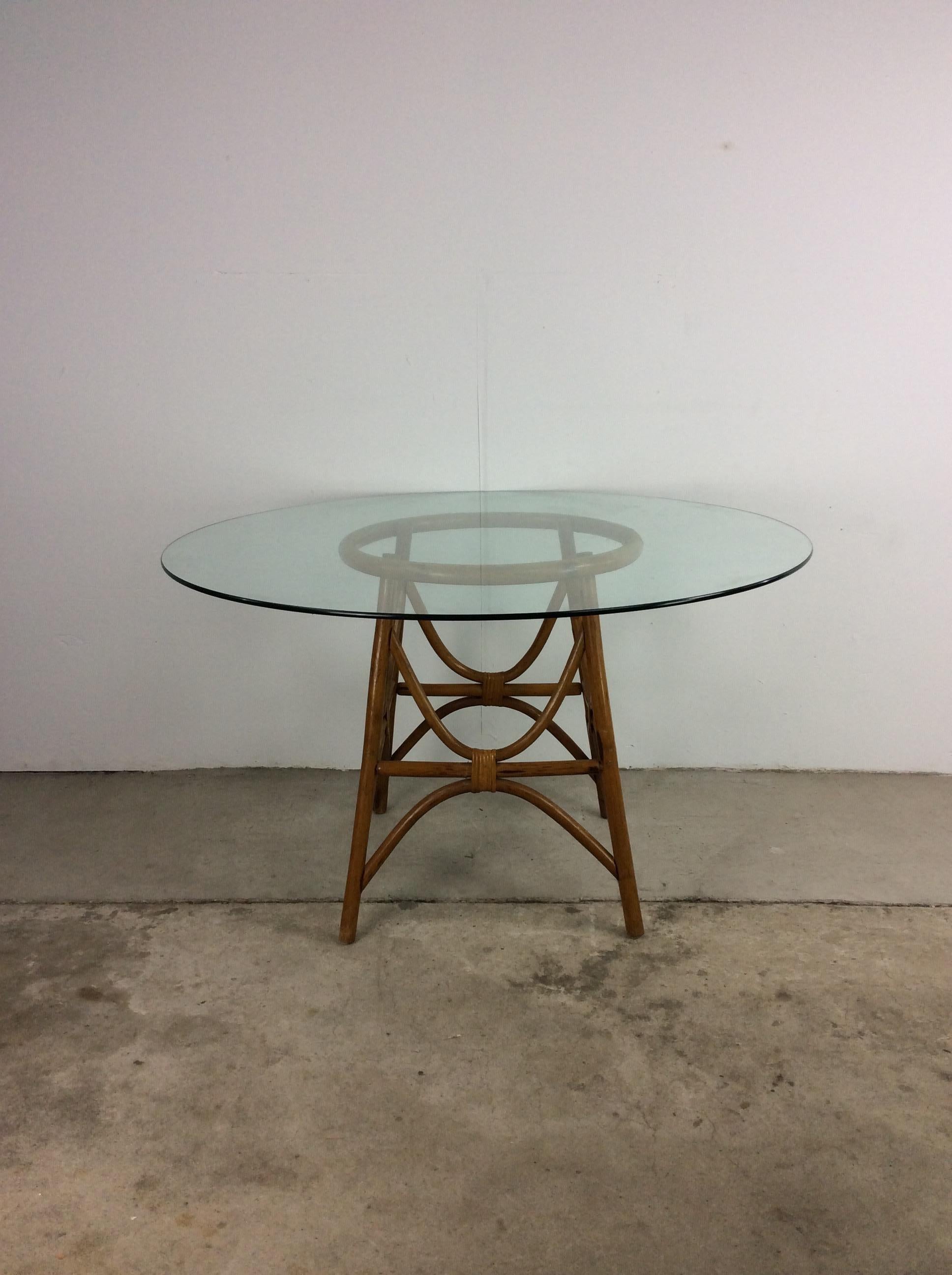 Cette table vintage Boho Chic présente un plateau rond en verre et une base en rotin à piédestal.

Les 4 chaises pivotantes assorties sont disponibles séparément.

Dimensions : 47.5w 47.5 28.5h

Condit : La base en rotin est robuste mais présente