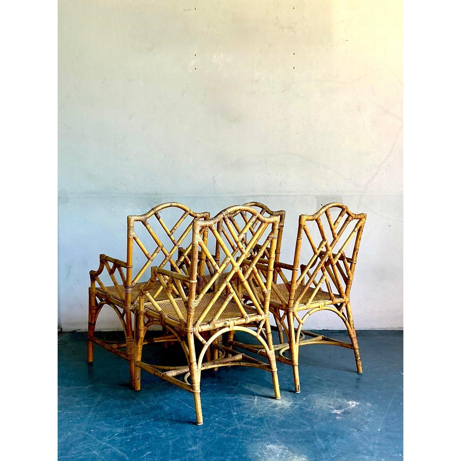 Llama la atención y desprende una sofisticación atemporal con este excepcional conjunto de cuatro sillones de comedor Chippendale chinos de época. Magistralmente elaboradas a mano con bambú natural, cada silla muestra el icónico calado geométrico y