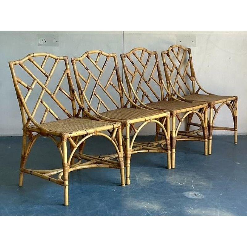 Infuse your home with the timeless elegance of Chinoiserie design with this stunning set of four vintage bamboo dining chairs. Expertly handcrafted from natural bamboo, each chair showcases the iconic geometric fretwork that defines the coveted