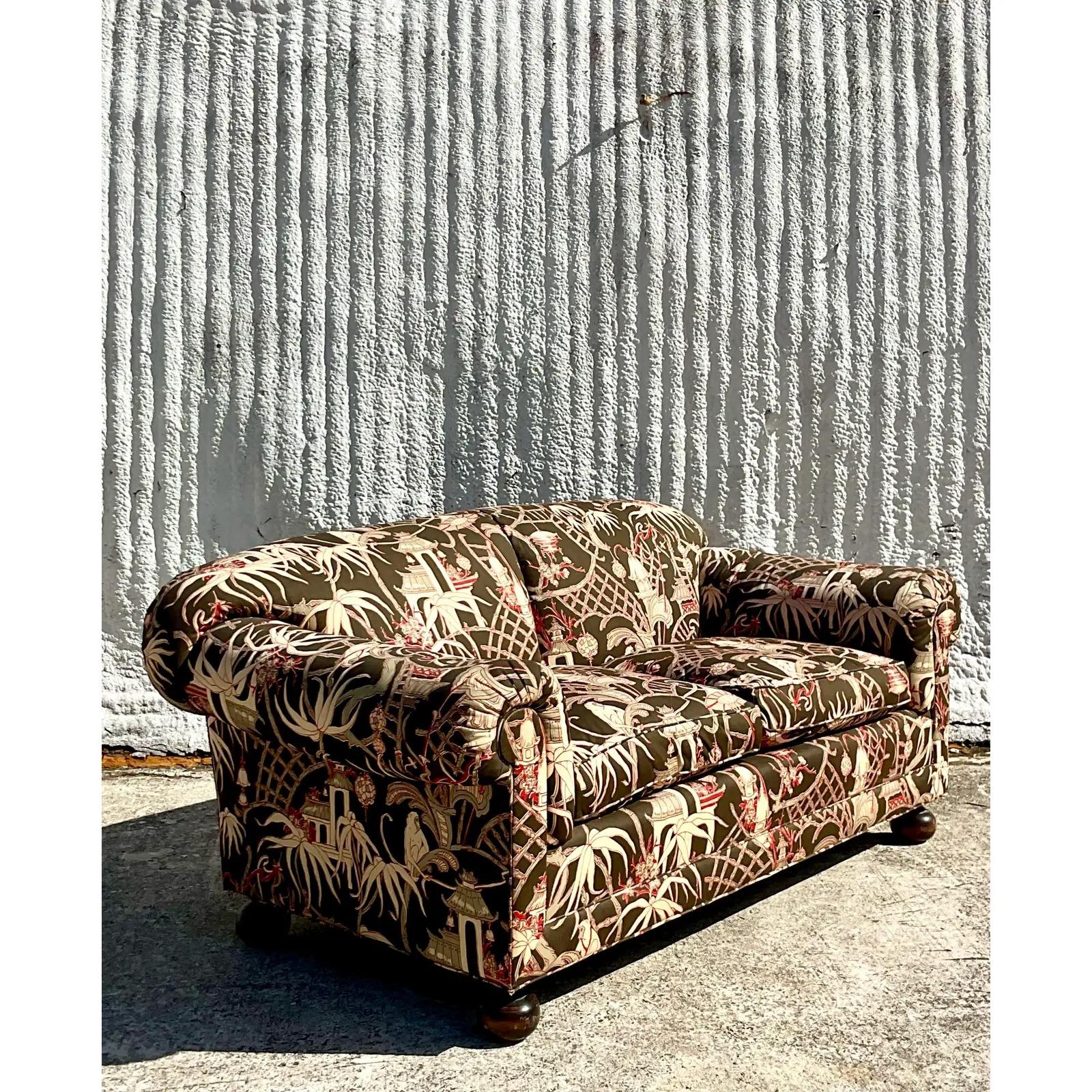 An incredible vintage Boho roll arm sofa. A beautiful Chinoiserie print in chocolate brown and persimmon. Two matching sofas available. Acquired from a Palm Beach estate.