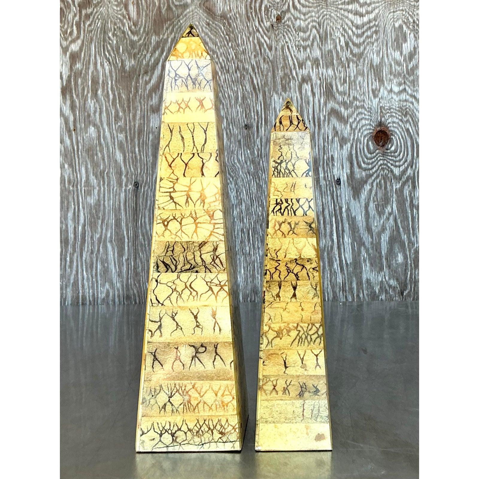 Apportez un élément de raffinement artistique à votre espace avec ce saisissant ensemble de deux obélisques vintage en coquille de noix de coco. Ces éléments décoratifs uniques présentent un motif envoûtant de coquille de noix de coco naturelle avec