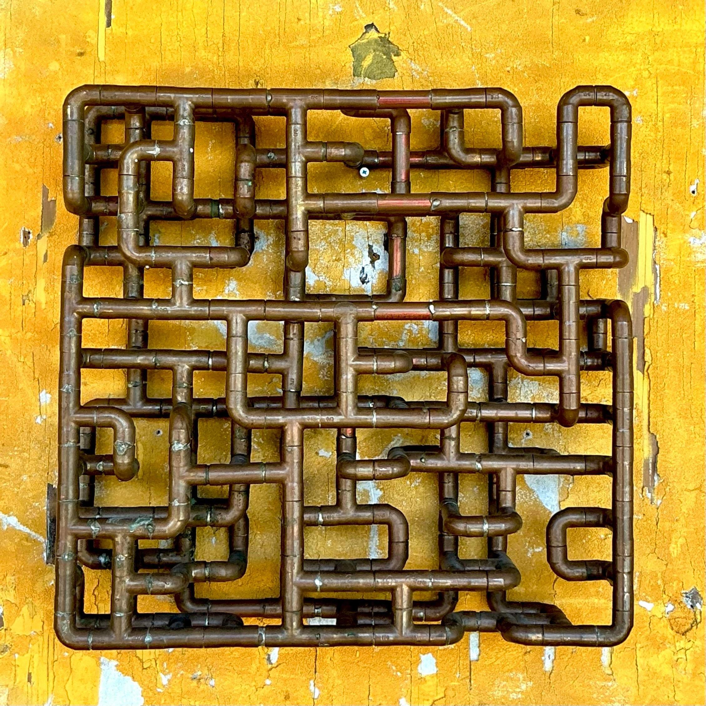 Questa scultura di tubo di rame vintage Boho incarna l'essenza eclettica e artigianale dello stile boho americano. Realizzato con tubi di rame riutilizzati, unisce il fascino industriale alla creatività artistica, diventando un pezzo unico e