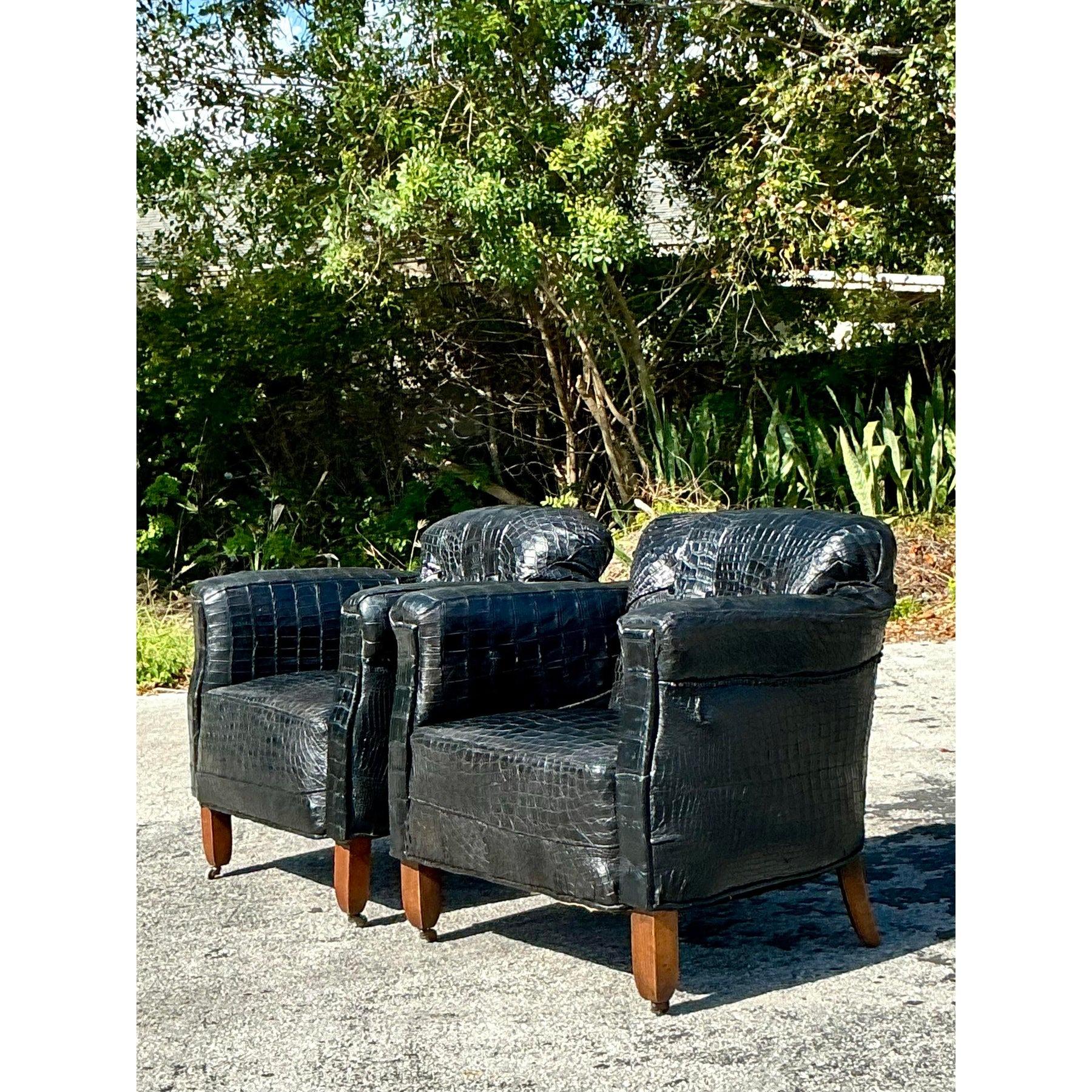 Add a bold statement to your space with this striking pair of vintage crocodile-embossed lounge chairs. Upholstered in a luxurious black faux-crocodile leather, these chairs exude a chic and sophisticated appeal, perfect for those who love a touch