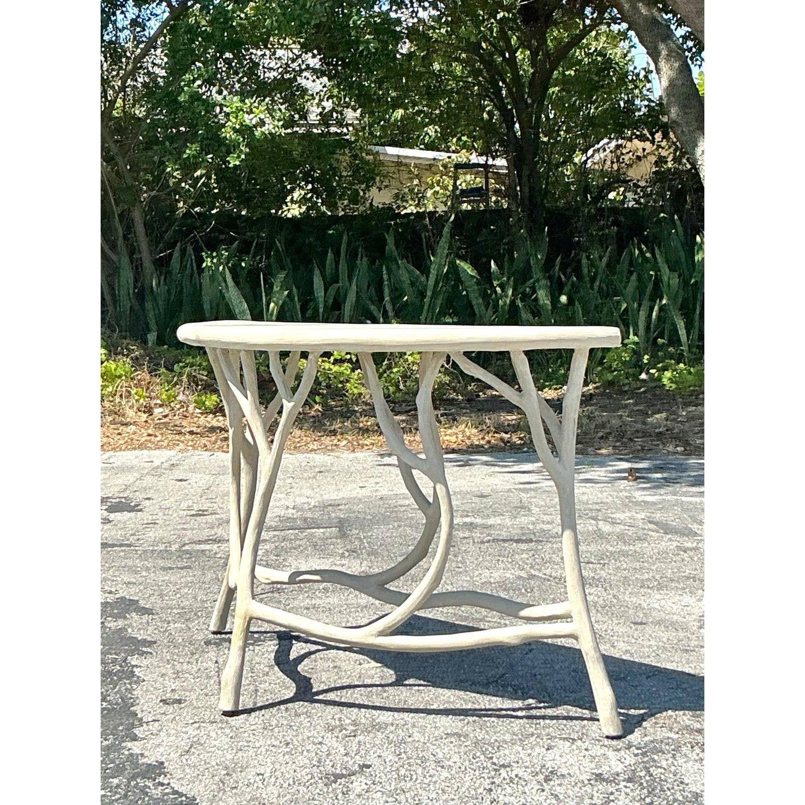 Capture the essence of organic beauty with this stunning vintage faux bois cement console table by Currey & Company. Designed to mimic the rustic elegance of natural wood, this piece showcases an intricate branch-like base that exudes artisanal