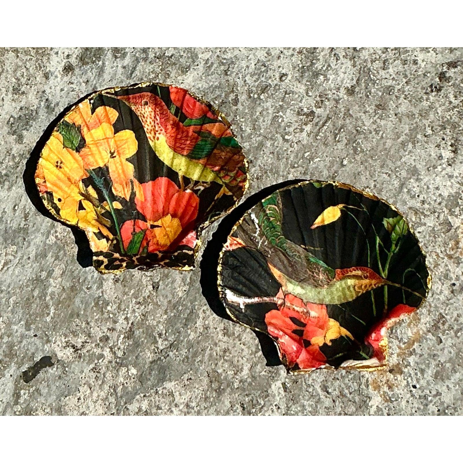 Infunde a tu espacio un color vibrante y un encanto artesanal con este impresionante conjunto de Conchas de Ostra Vintage Boho Decoupage. Cada concha presenta un animado colibrí entre flores brillantes sobre un fondo negro intenso, un llamativo