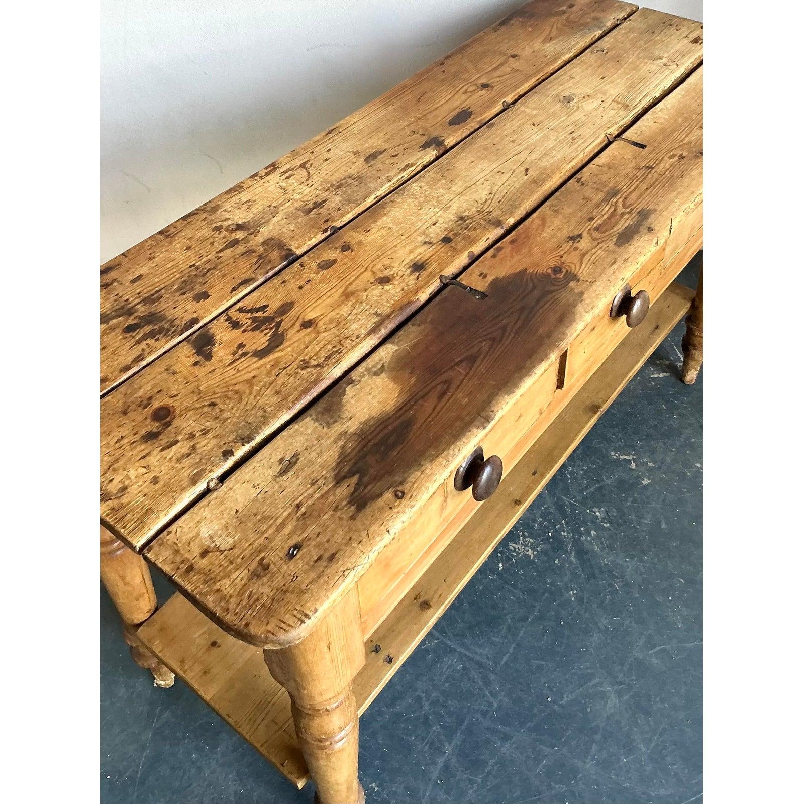 Infuse your home with the authentic, rustic charm of a Provencal farmhouse with this vintage pine console table. Crafted from solid wood, this piece radiates warmth with its honey-toned finish and honest, utilitarian construction. It features three