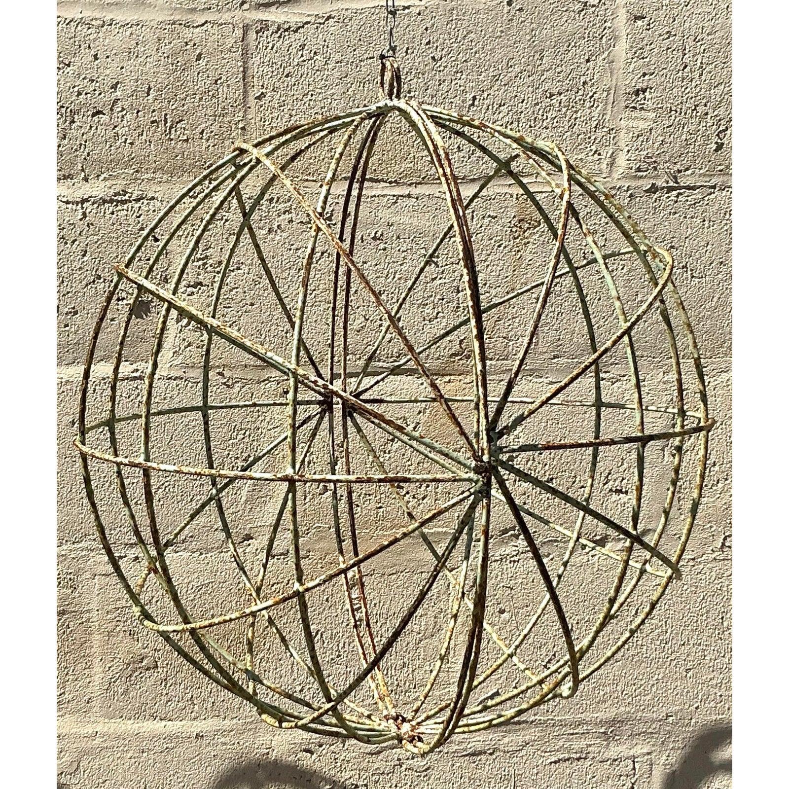 Add an effortlessly chic, sculptural touch to your home or garden with this striking pair of vintage distressed iron spheres. With their openwork, globe-like design and naturally aged patina, these pieces exude organic bohemian charm and a curated,