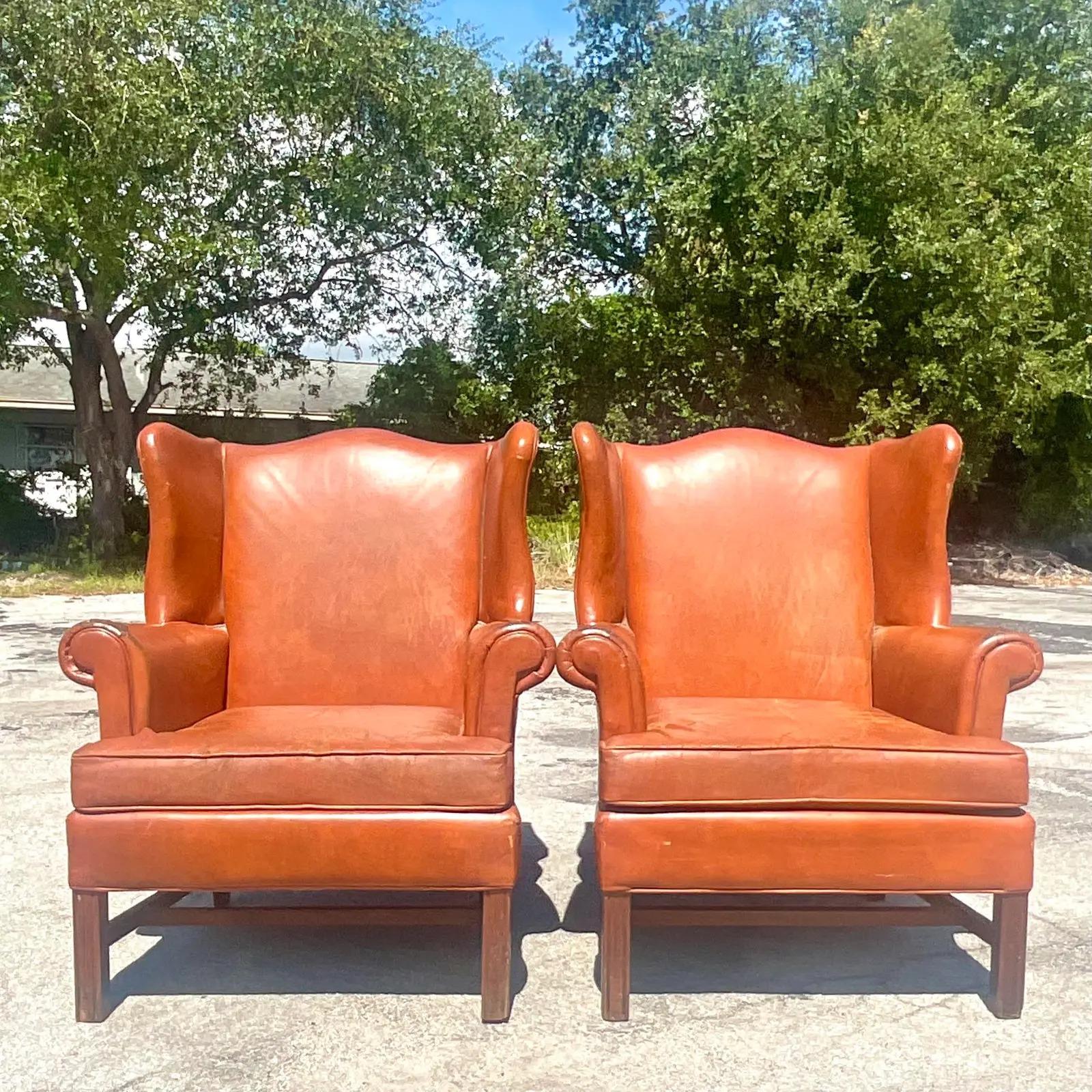 A spectacular pair of vintage Boho wingback chairs. Done in a distressed leather with lots of crackling and tears from time. The perfect amount of patina from time. Super chic. Acquired from a Palm Beach estate.

The chairs are in great vintage