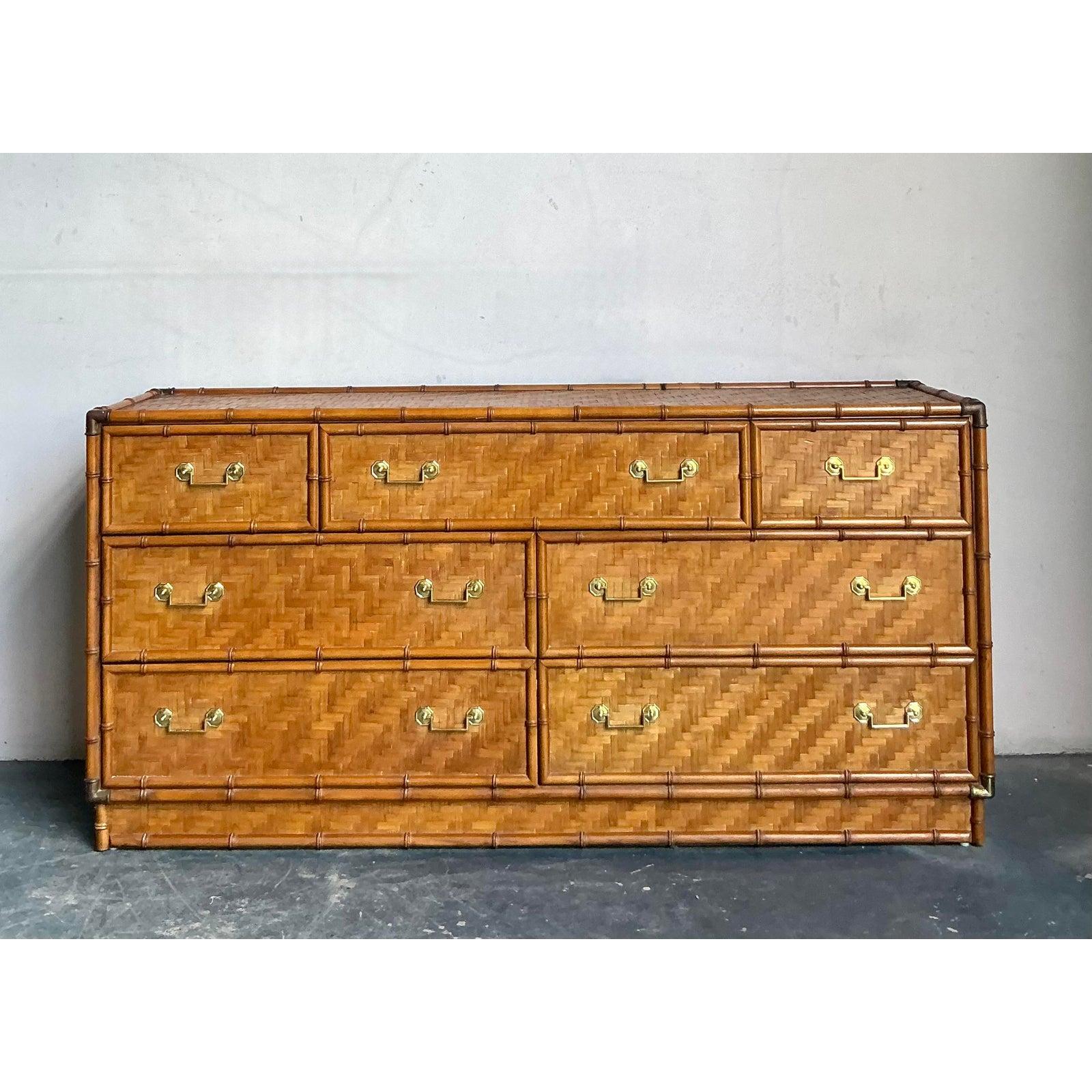 Questo sorprendente comò di Dixie Furniture cattura l'essenza del design Hollywood Regency e Coastal degli anni '70, utilizzando una costruzione altamente dettagliata in finto bambù e rattan. L'intero pezzo, compresi il piano e i frontali dei