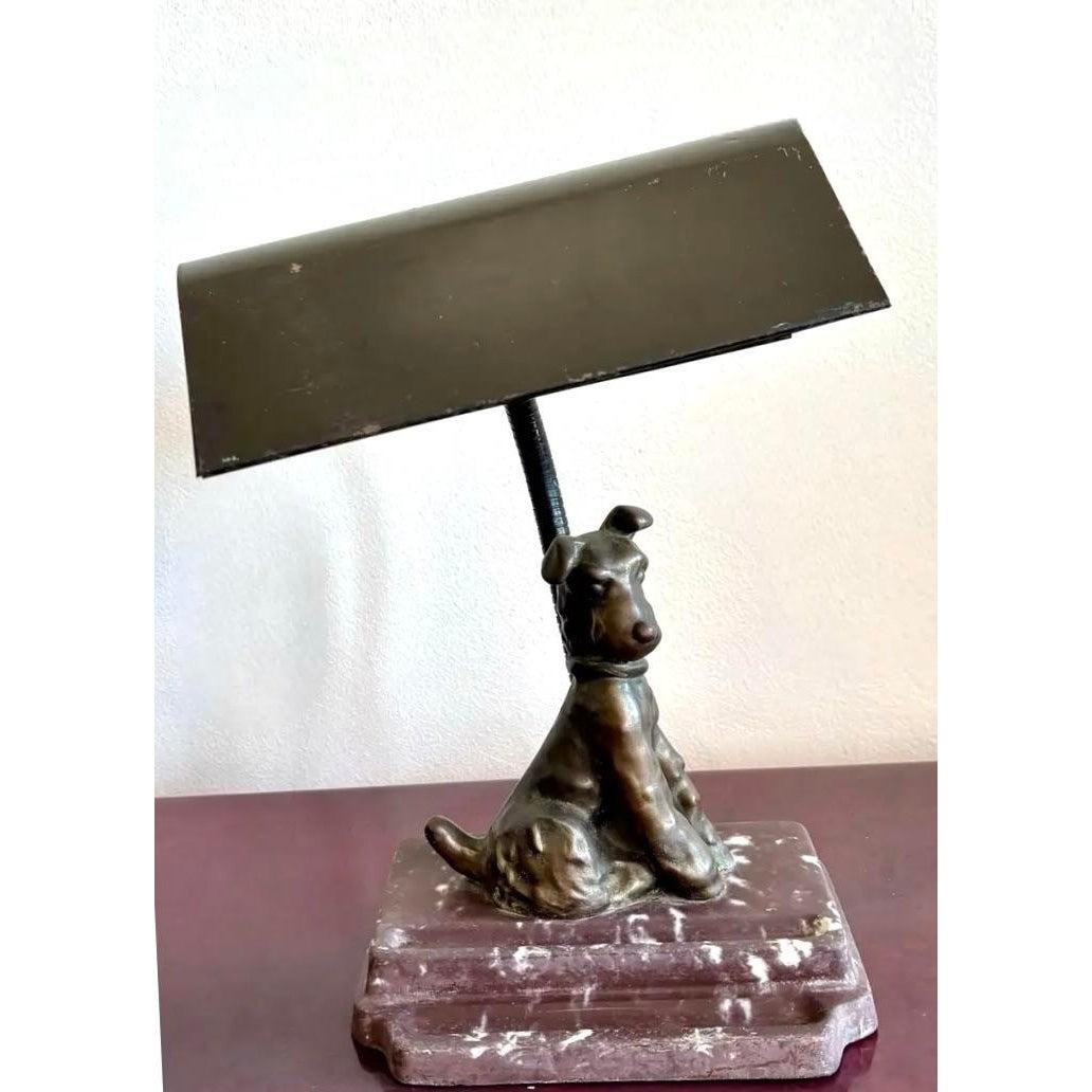 This charming desk lamp blends whimsical character with vintage charm, featuring a loyal pup cast in bronze perched atop a weighty marble base. The dog’s poised yet relaxed posture adds a sense of personality and nostalgia, as though waiting